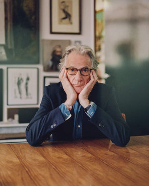 Paul Smith brand creator of PS Paul Smith sitting at a table with head in his hands