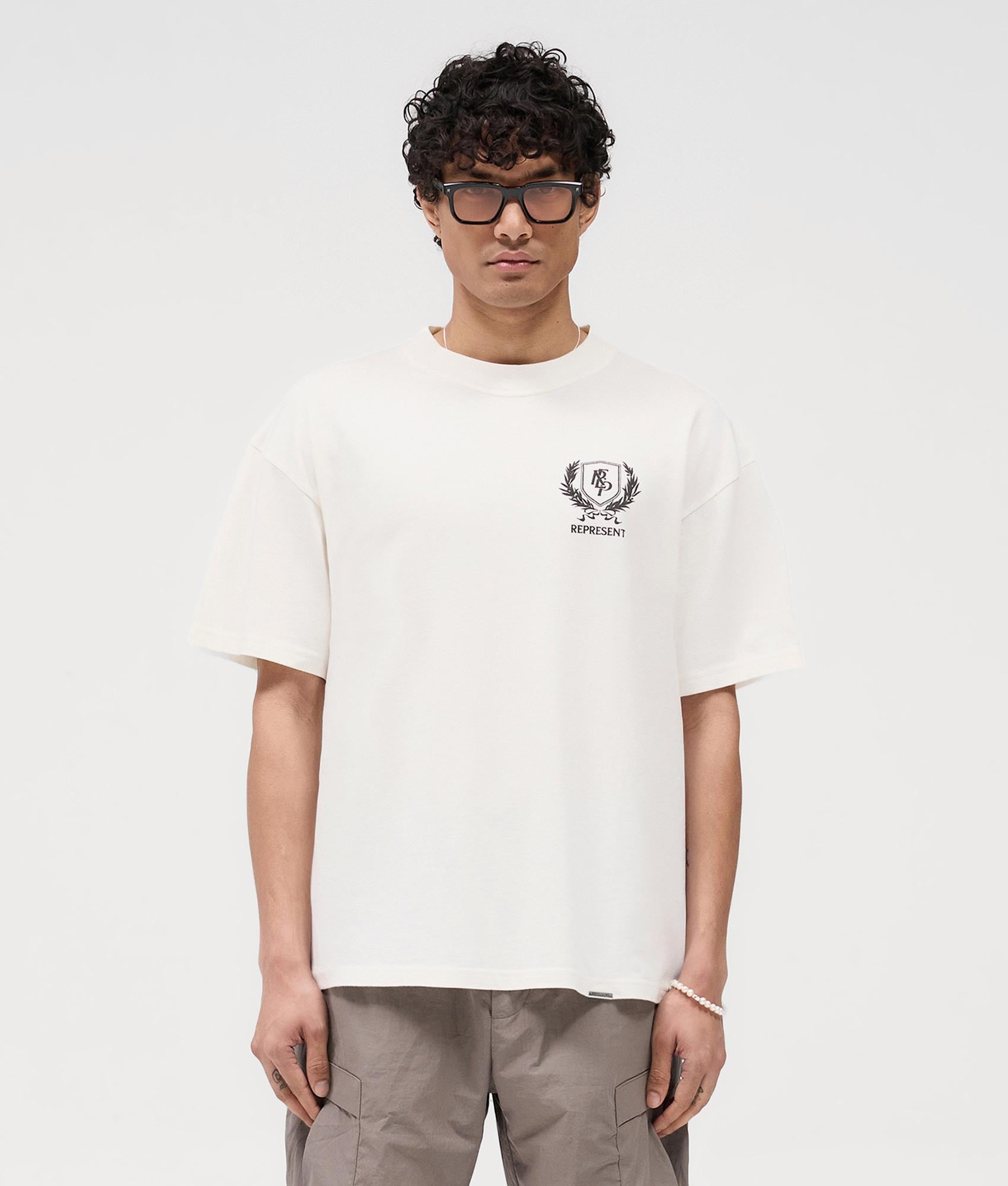 Represent Crest T-Shirt in Flat White at EQvVS. Front Model Shot