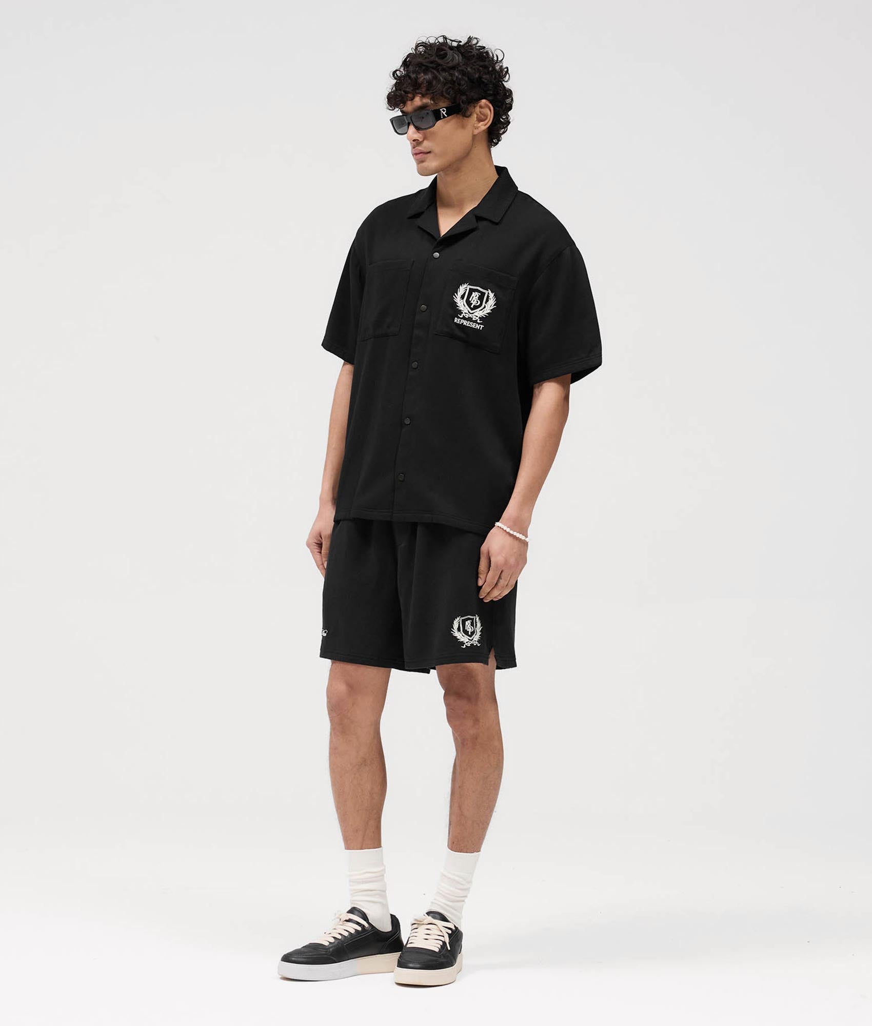 Represent Represent Crest Shorts in Black at EQVVS. Model Front shot.