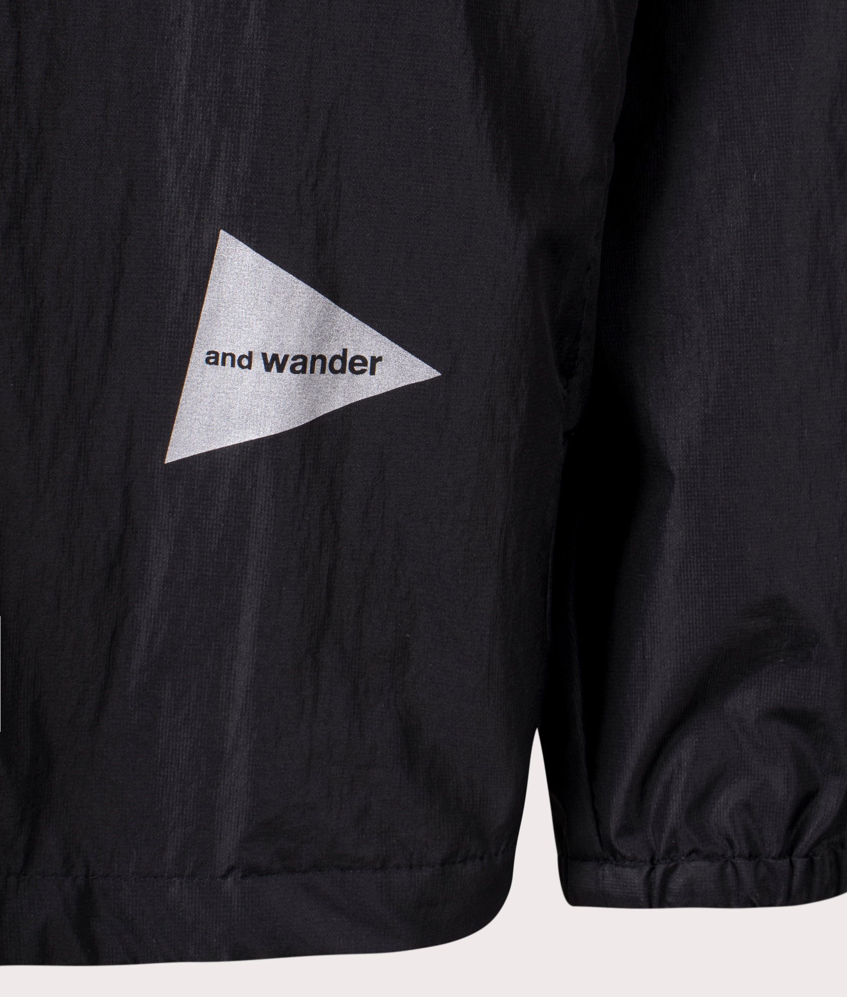 and Wander Oversized Rip Jacket in Black. Shot at EQVVS. Front hip logo shot 