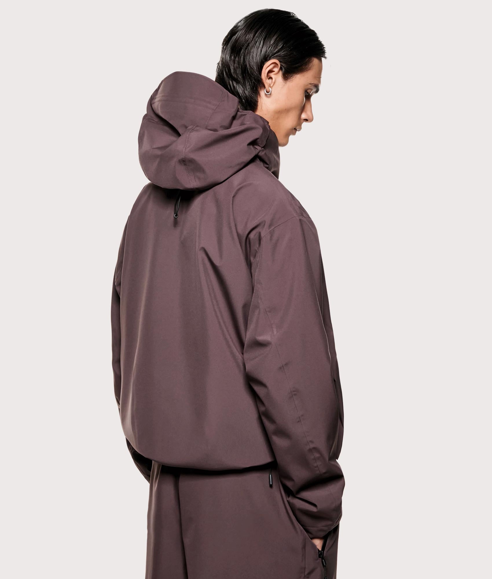 MKI MIYUKI ZOKU V3 Shell Hooded Jacket in Raisin at EQVVS Menswear. Angled model back shot.