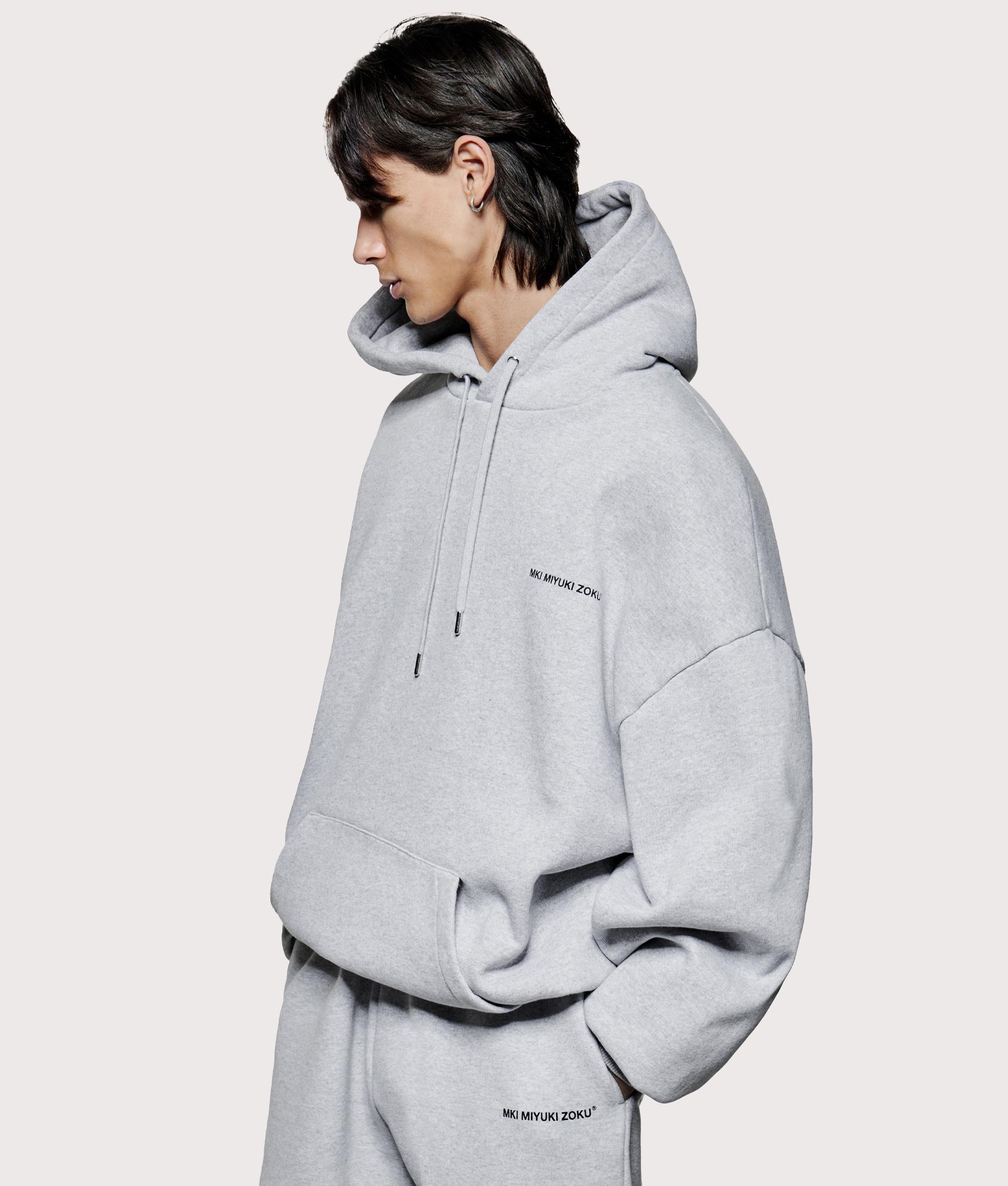 MKI MIYUKI ZOKU Oversized Uniform Hoodie at EQVVS Menswear. Model angle shot.