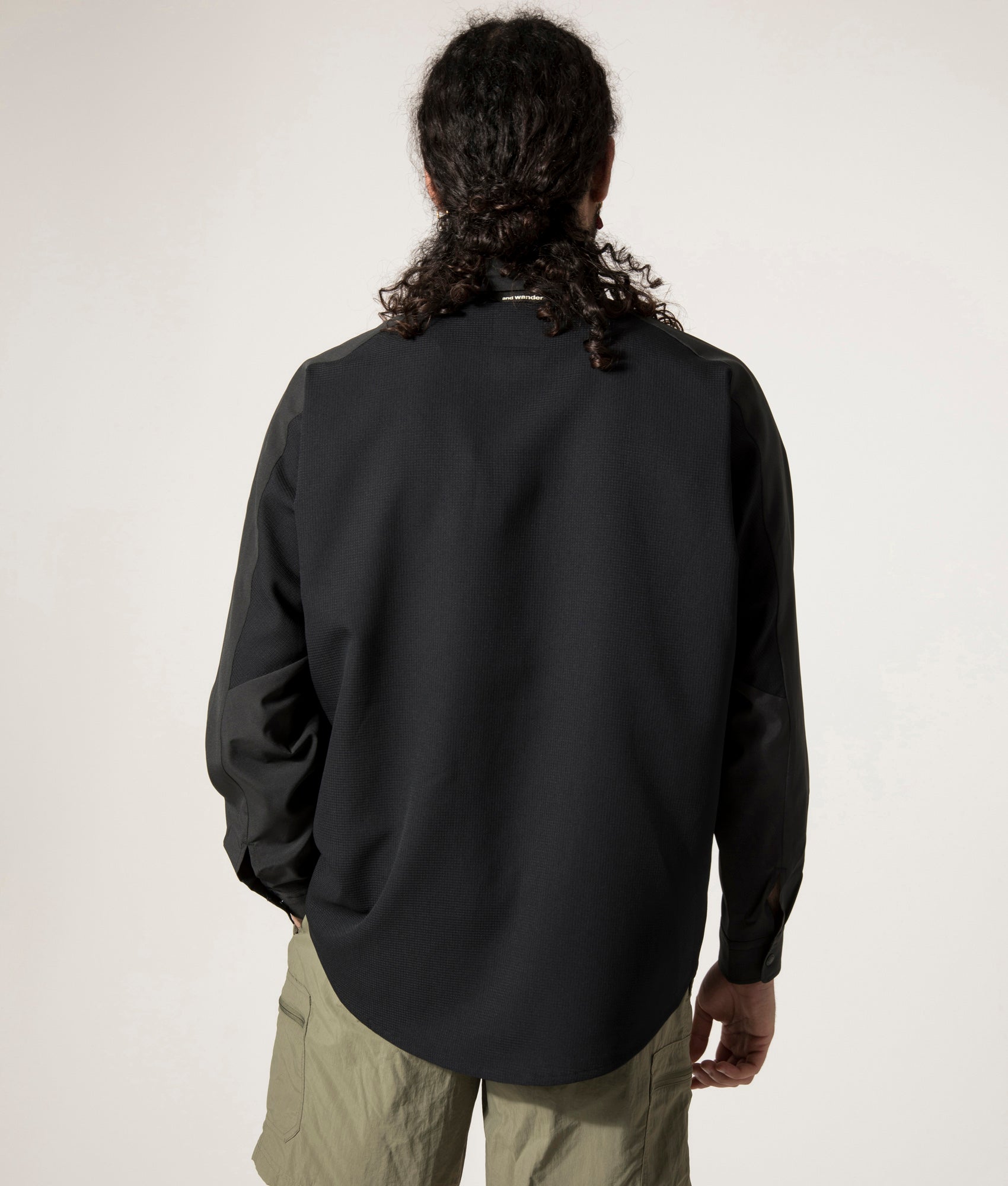 and wander Tech Shirt in Black. Shot at EQVVS. Back Model Shot.