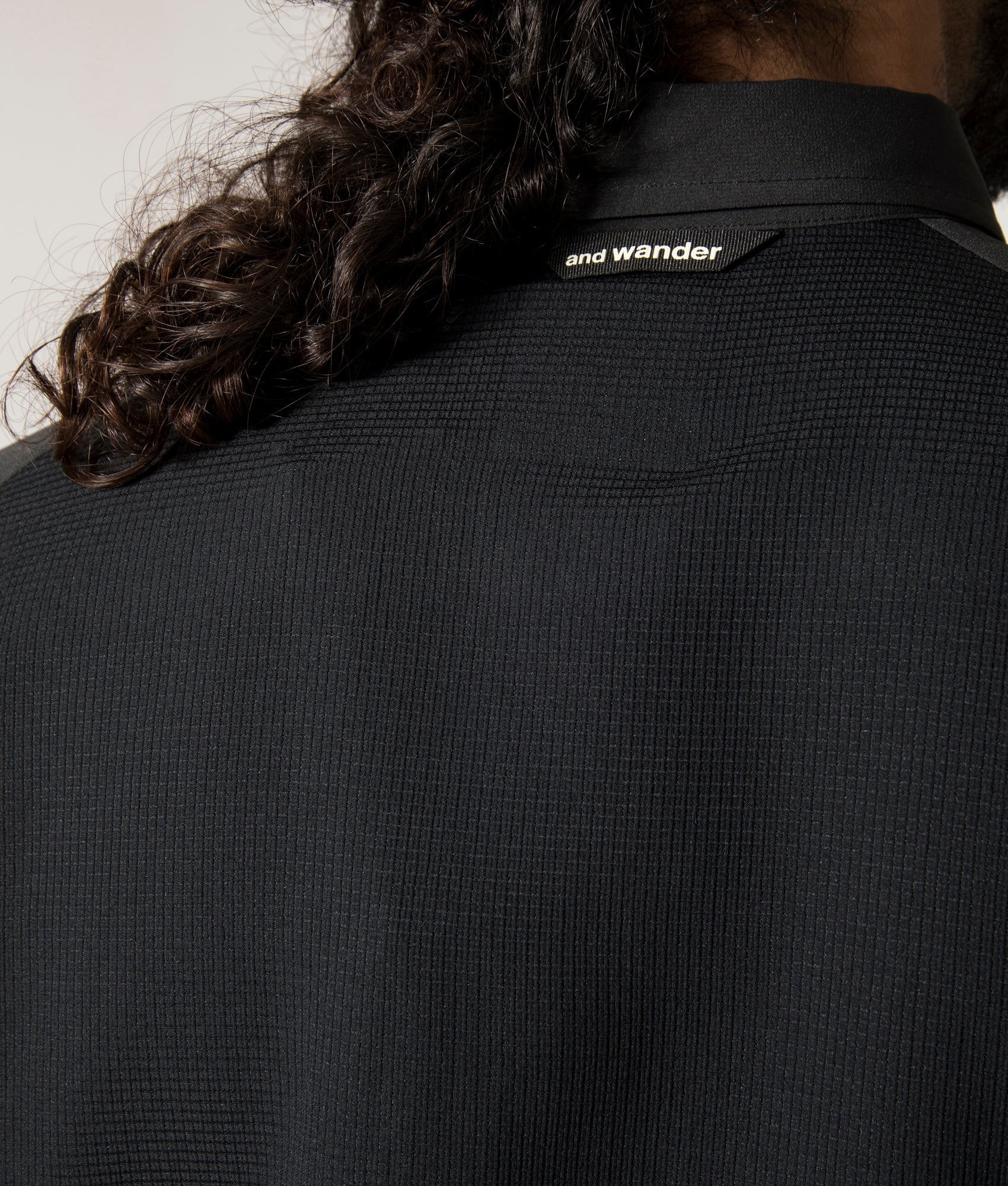 and wander Tech Shirt in Black. Shot at EQVVS. Back Detail Model Shot.