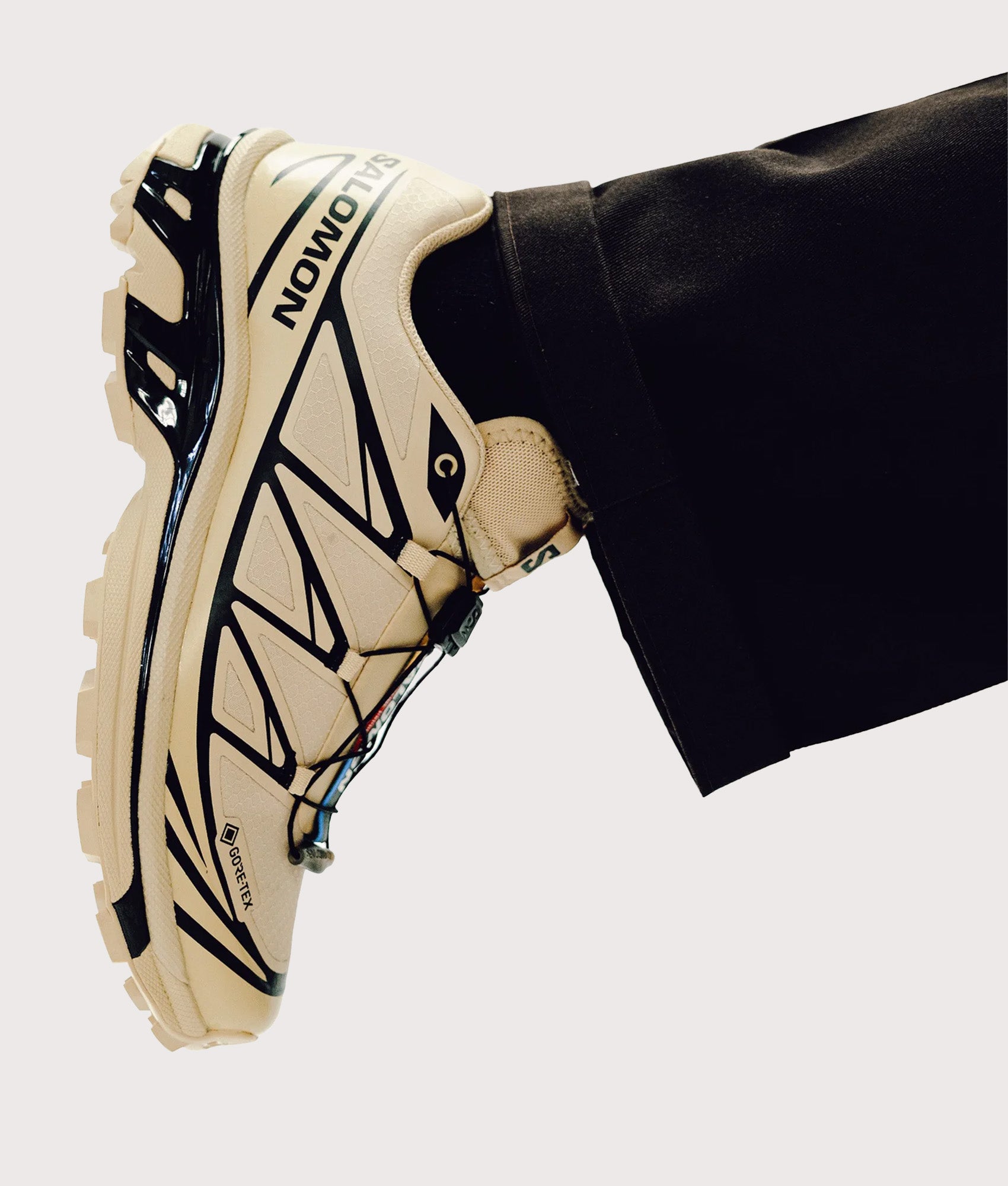 SALOMON XT-6 GTX Sneakers in Safari and Black at EQVVS Menswear. Model shot.