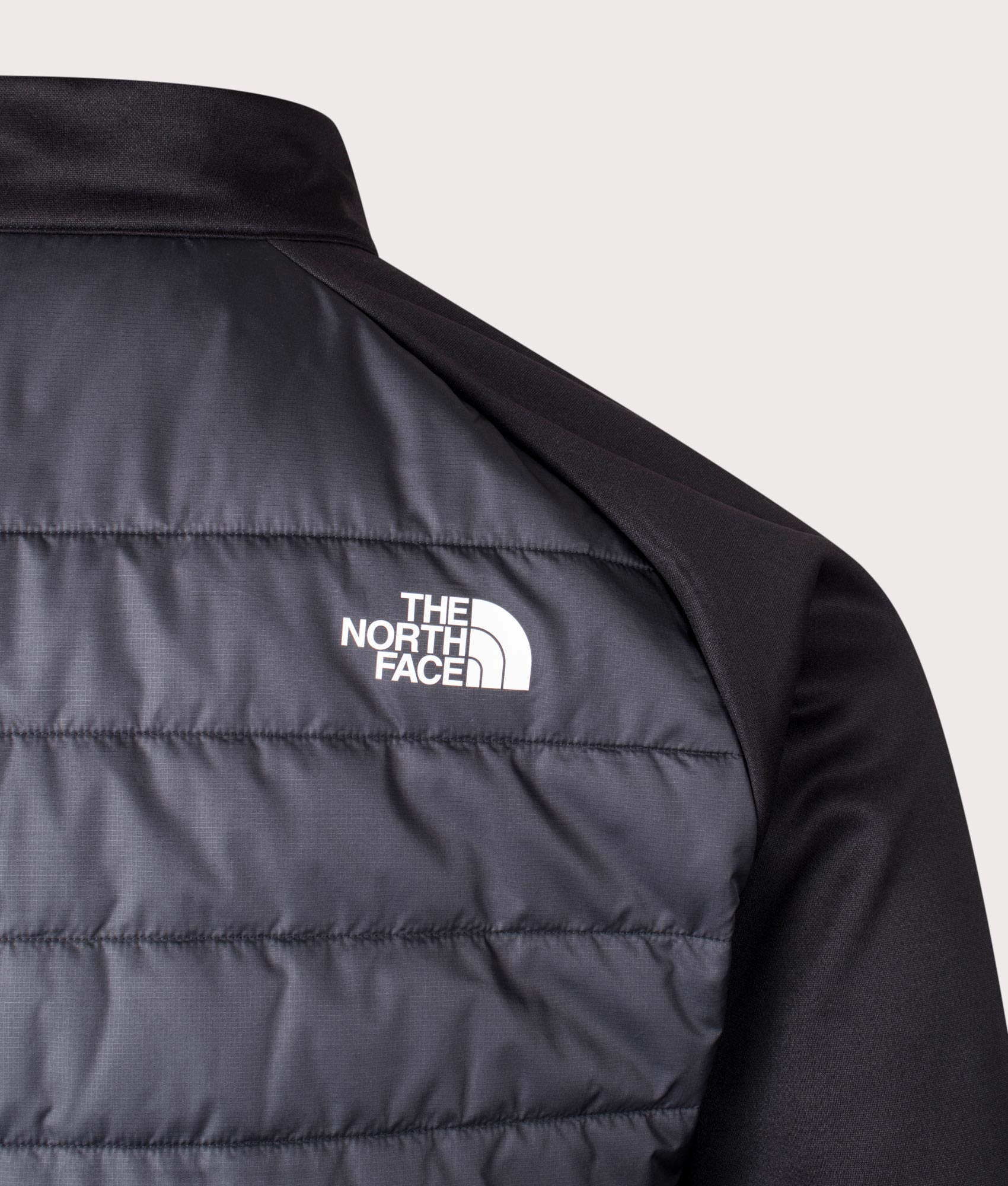 The North Reaxion Hybrid Jacket in Black and Asphalt Grey at EQVVS. Back Detail Shot.