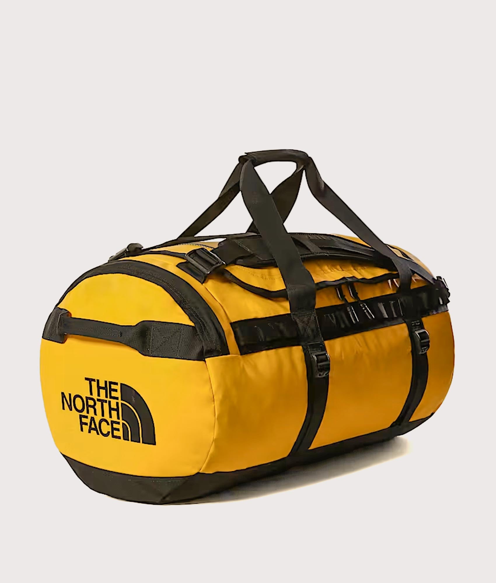 The North Face Large Base Camp Duffel Bag in Summit Gold and TNF Black at EQVVS Menswear. Angled front shot.