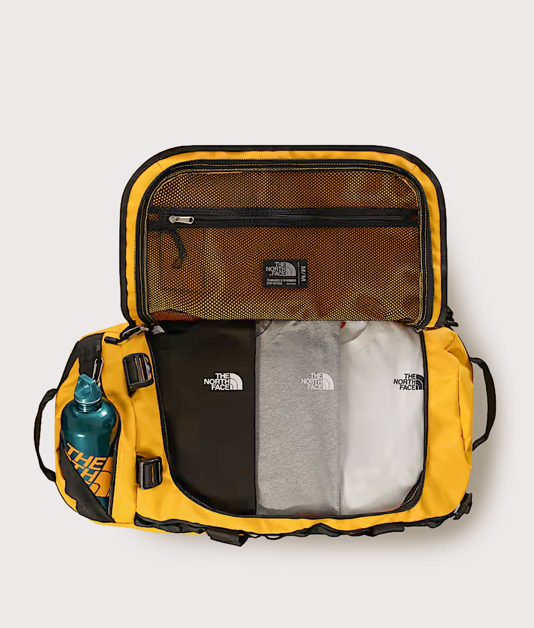 The North Face Large Base Camp Duffel Bag in Summit Gold and TNF Black at EQVVS Menswear. Open shot.