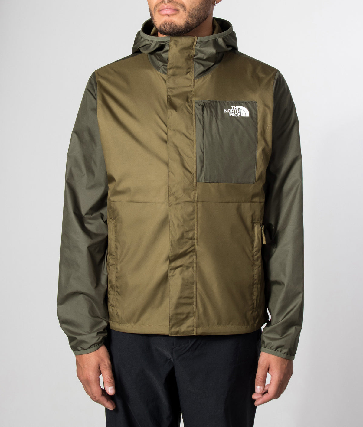 The North Face Regular Fit Nuketo Windbreaker in Caraway Seed and New Taupe Green at EQVVS Menswear. Model front shot.