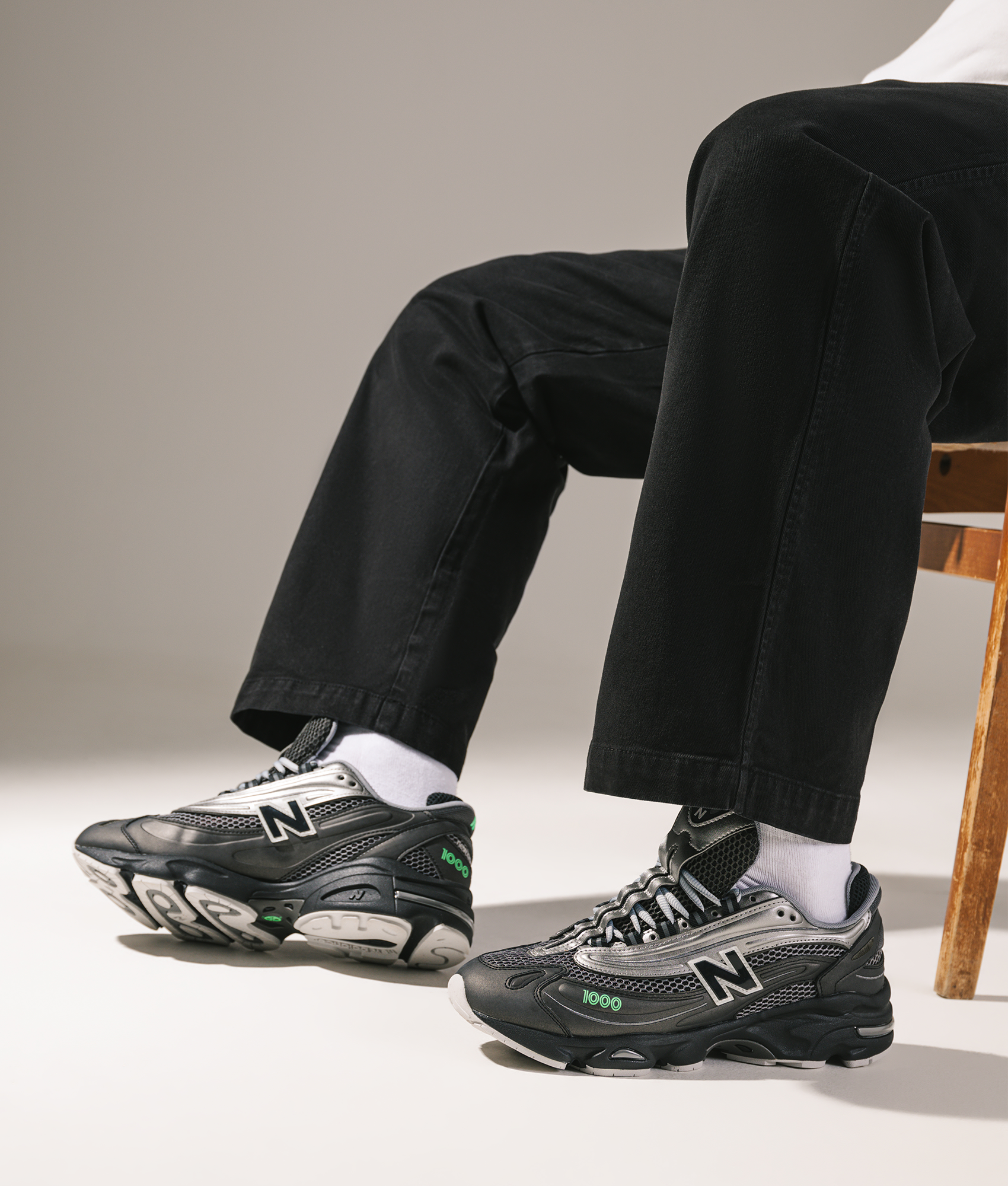 New Balance 1000 Sneakers in Black, Dark Silver Metallic and Lime Leaf at EQVVS Menswear. Campaign shot.