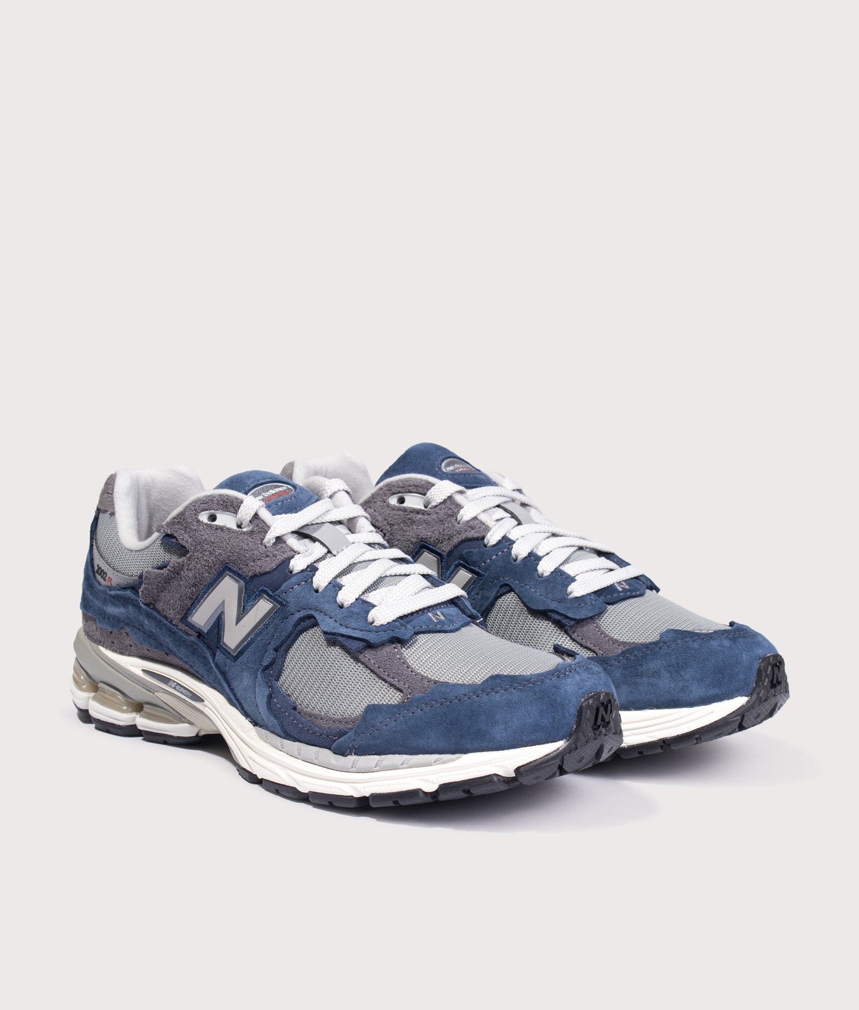 New Balance 2002D Protection Pack Sneakers in NB Navy at EQVVS Menswear. Angled front shot.