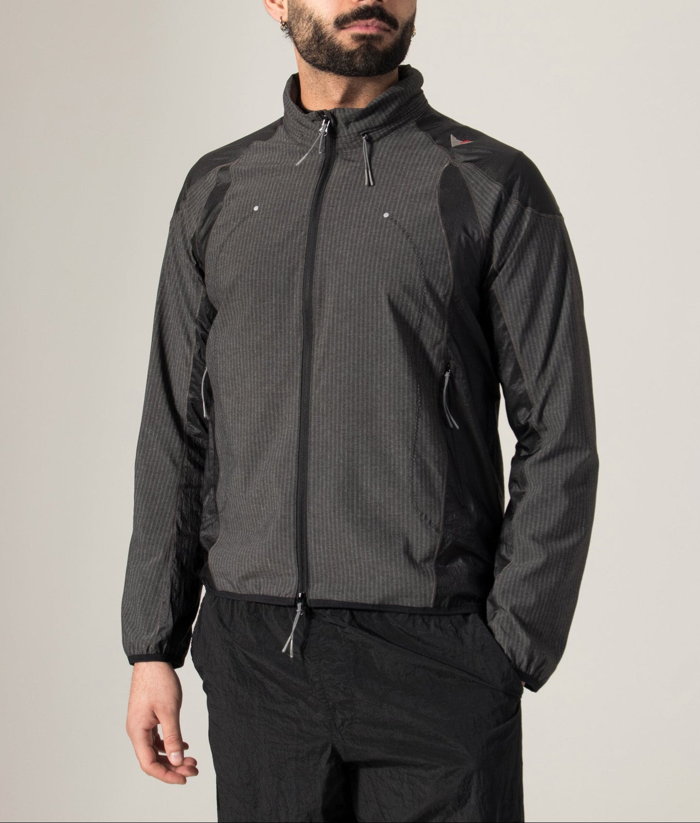ROA Numb Pinstriped Hooded Wind Jacket in Black at EQVVS Menswear. Model front shot.