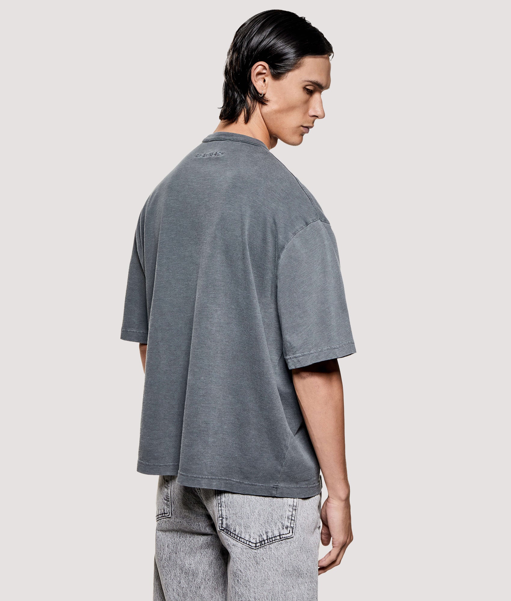 MKI MIYUKI ZOKU Box Fit 220 GSM Slub T-Shirt in Pigment Black at EQVVS Menswear. Angled model back shot.