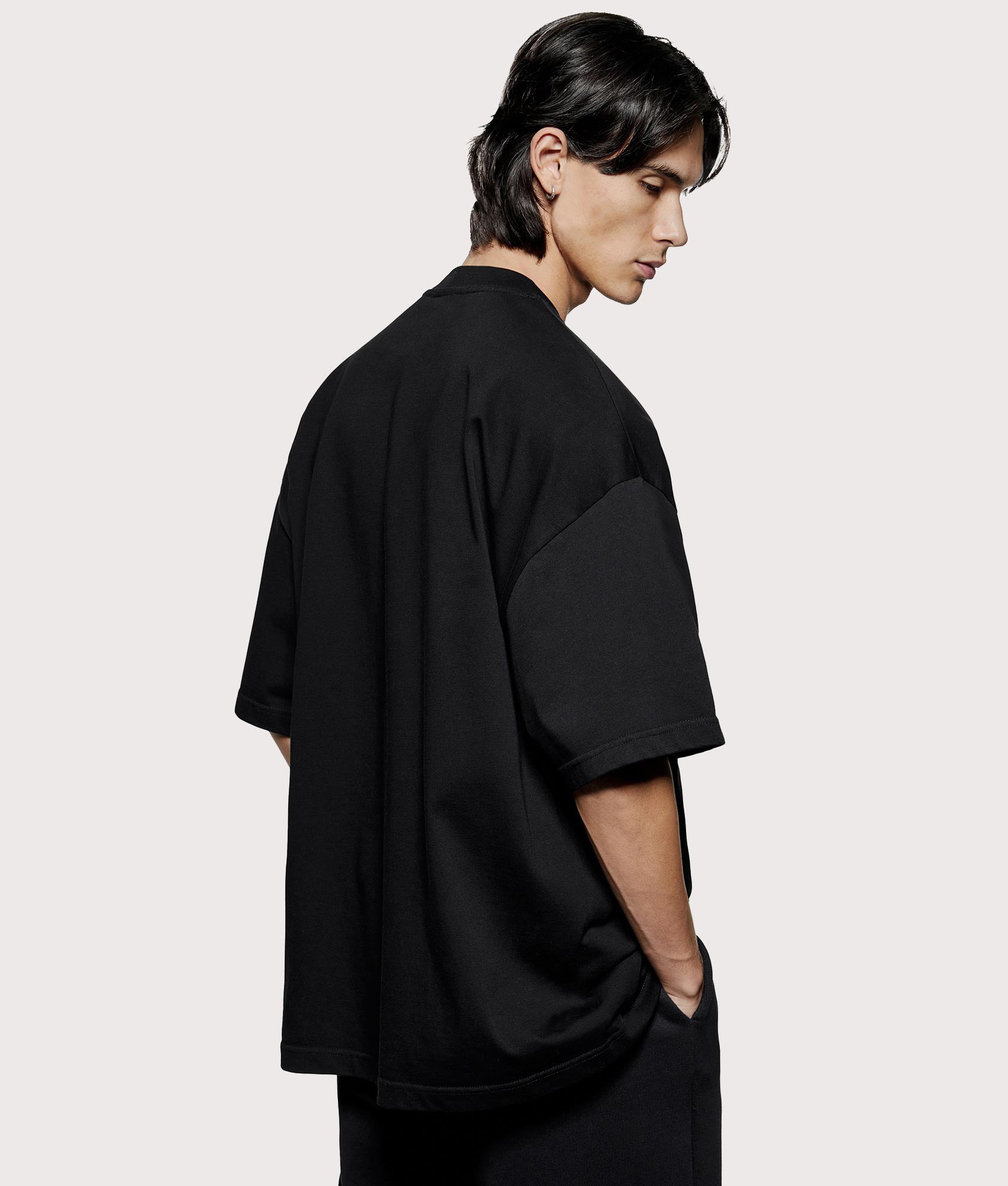 MKI MIYUKI ZOKU Oversized Uniform T-Shirt at EQVVS Menswear. Angled model back shot.