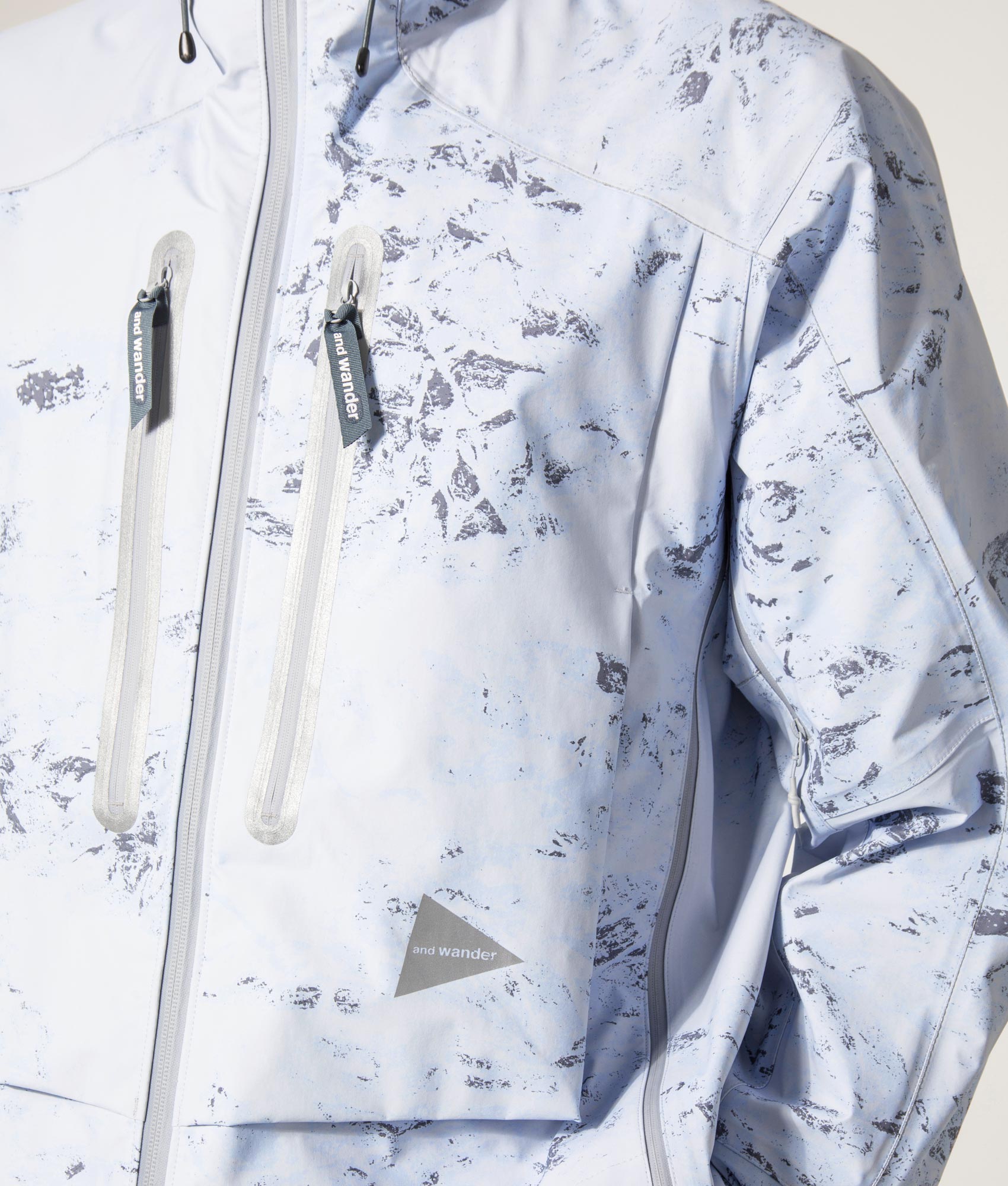 Pertex Shield Rain Jacket in Light Blue by And Wander at EQVVS Menswear. Detail Model Shot.