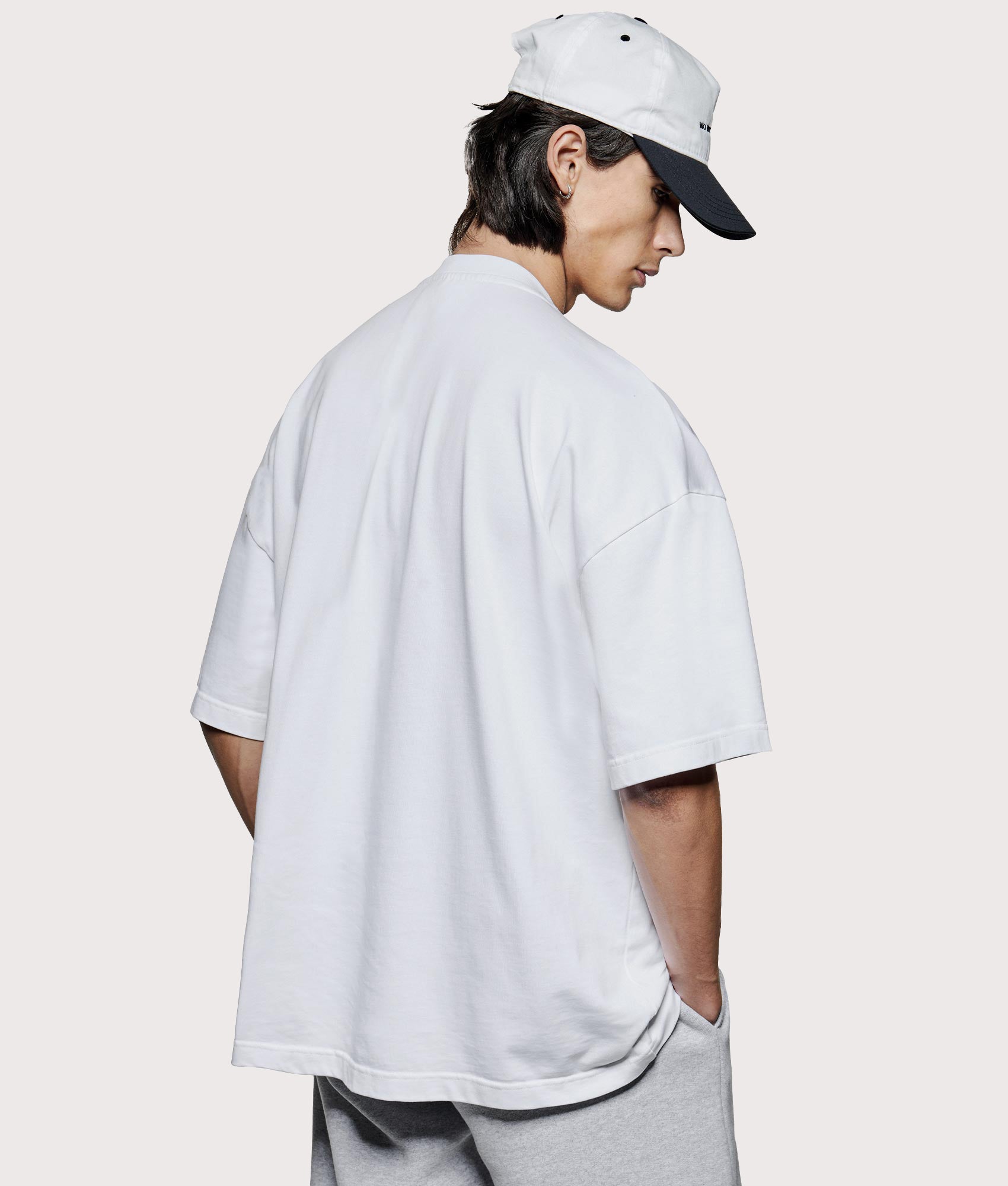 MKI MIYUKI ZOKU Oversized Uniform T-Shirt at EQVVS Menswear. Angled model back shot.