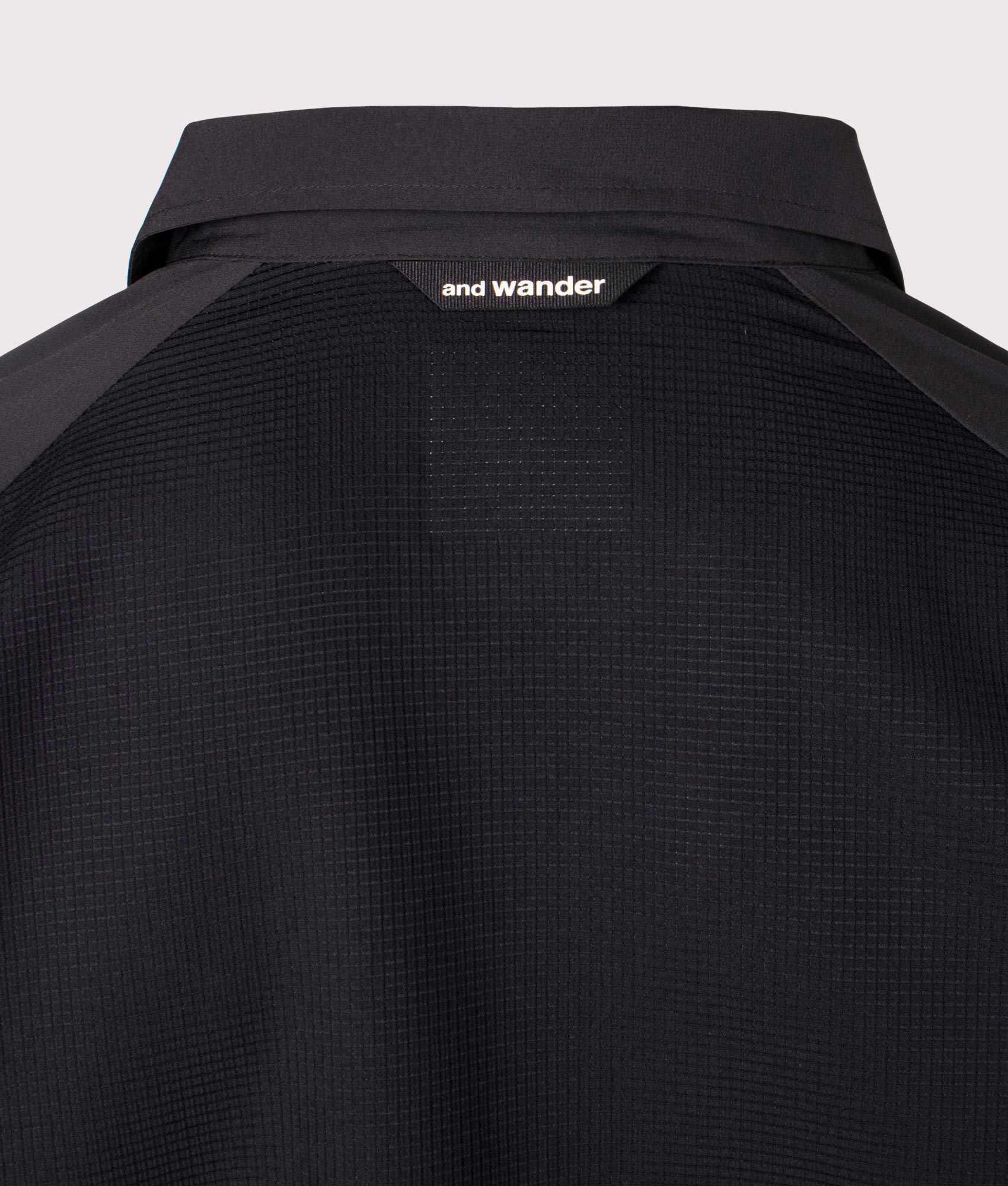 and wander Tech Shirt in Black. Shot at EQVVS. Back brand shot 