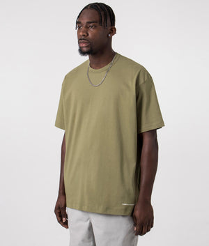 CDG Script Hem Logo T-Shirt in Khaki. Front side angle shot at EQVVS.