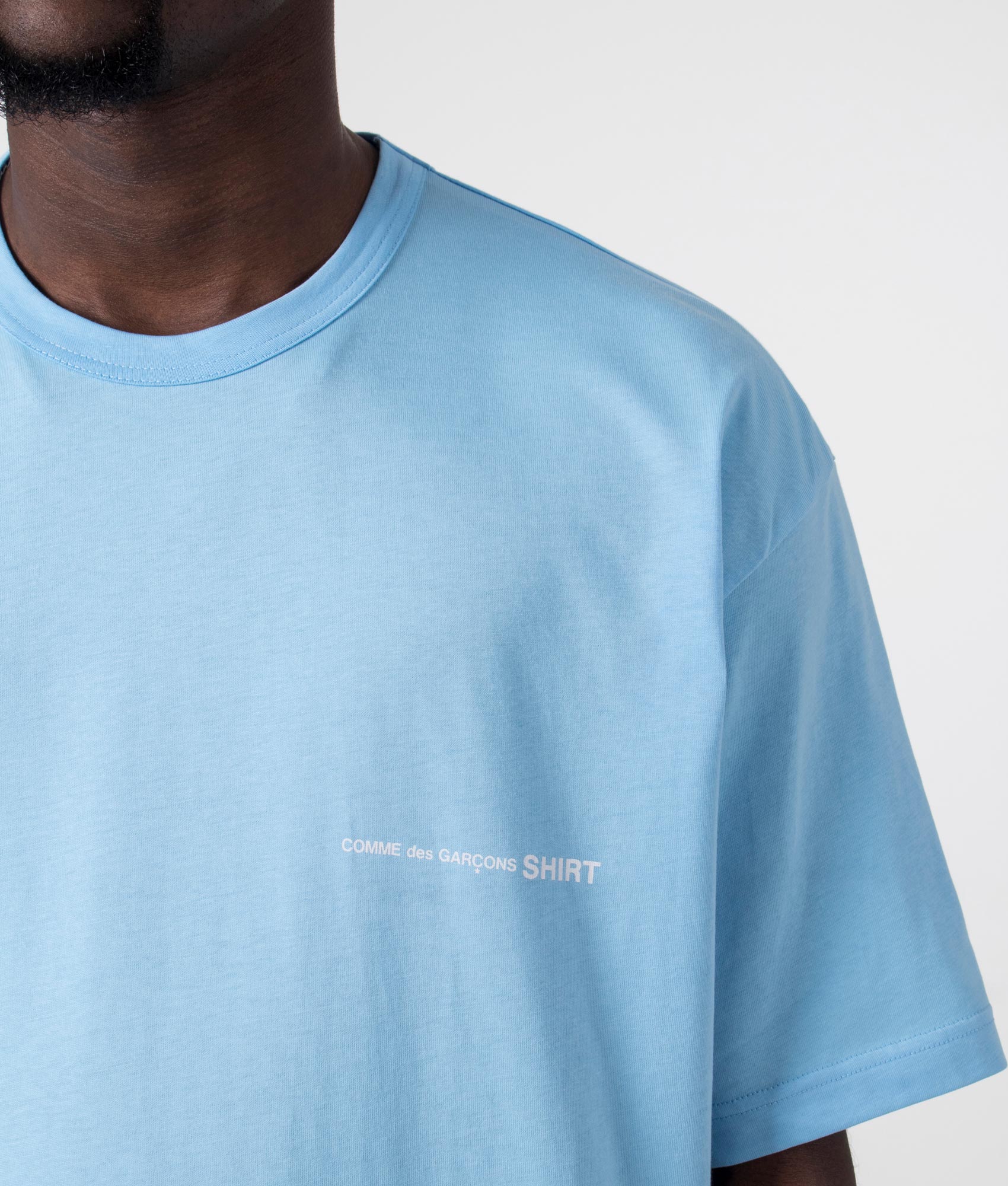 CDG Script Chest Logo T-Shirt in Blue. Detail shot at EQVVS.