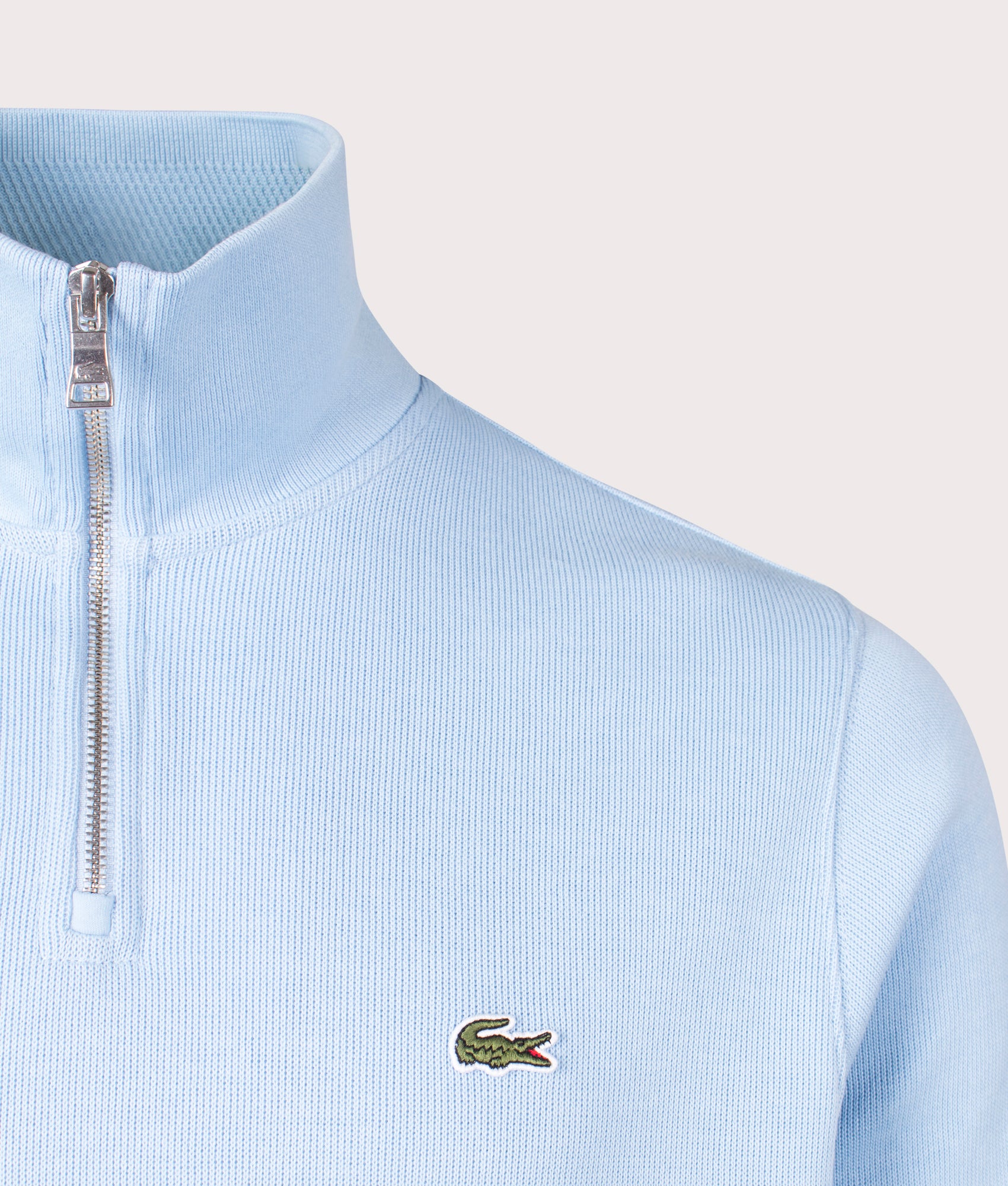 Lacoste Quarter Zip Croc Logo Sweatshirt in HBP Pale Blue, 100% Cotton. At EQVVS Menswear. Front logo shot