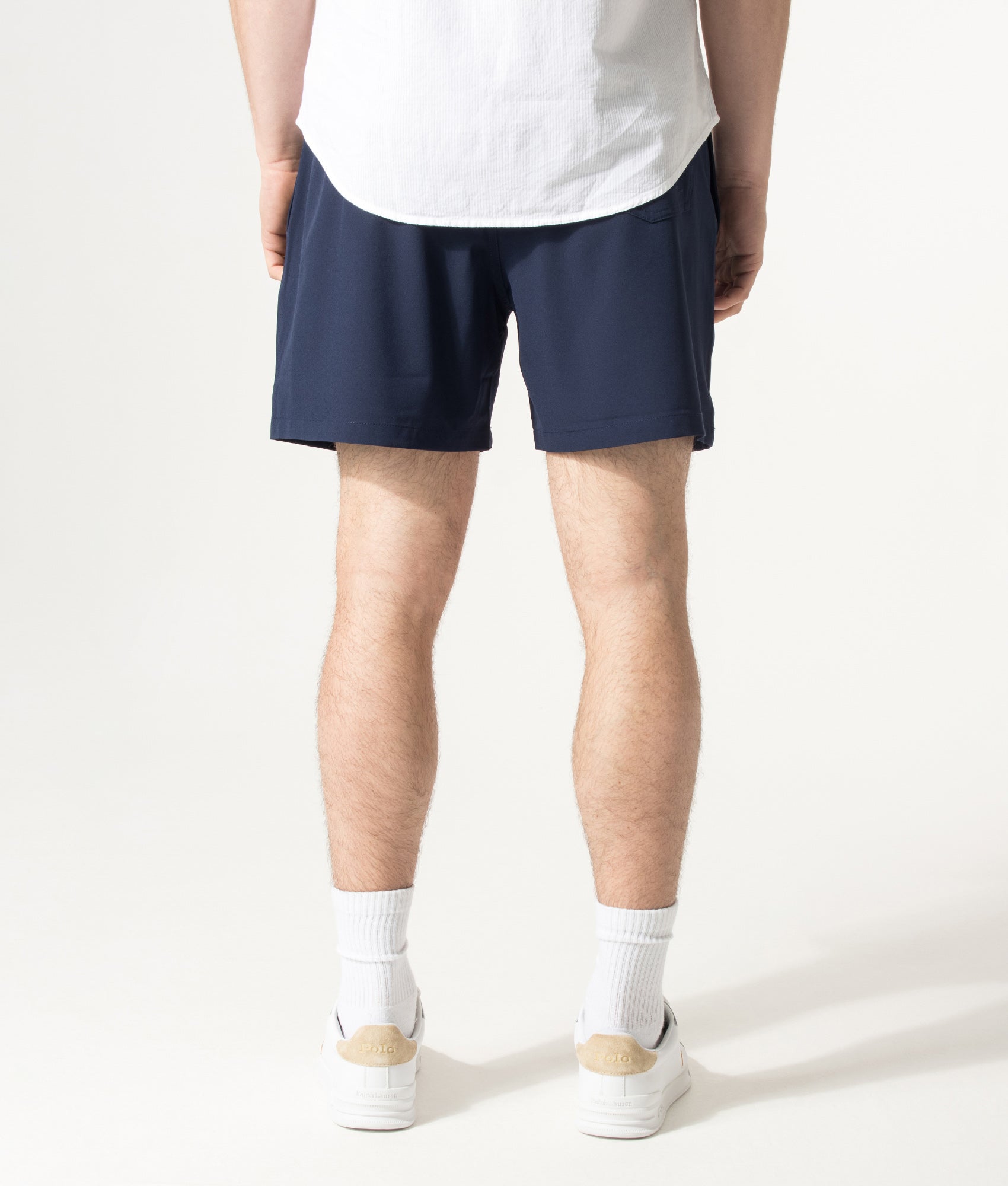 Polo Ralph Lauren 5.75 Inch Traveler Classic Swim Trunks in Cruise Navy and Emblem at EQVVS Menswear. Model back shot.