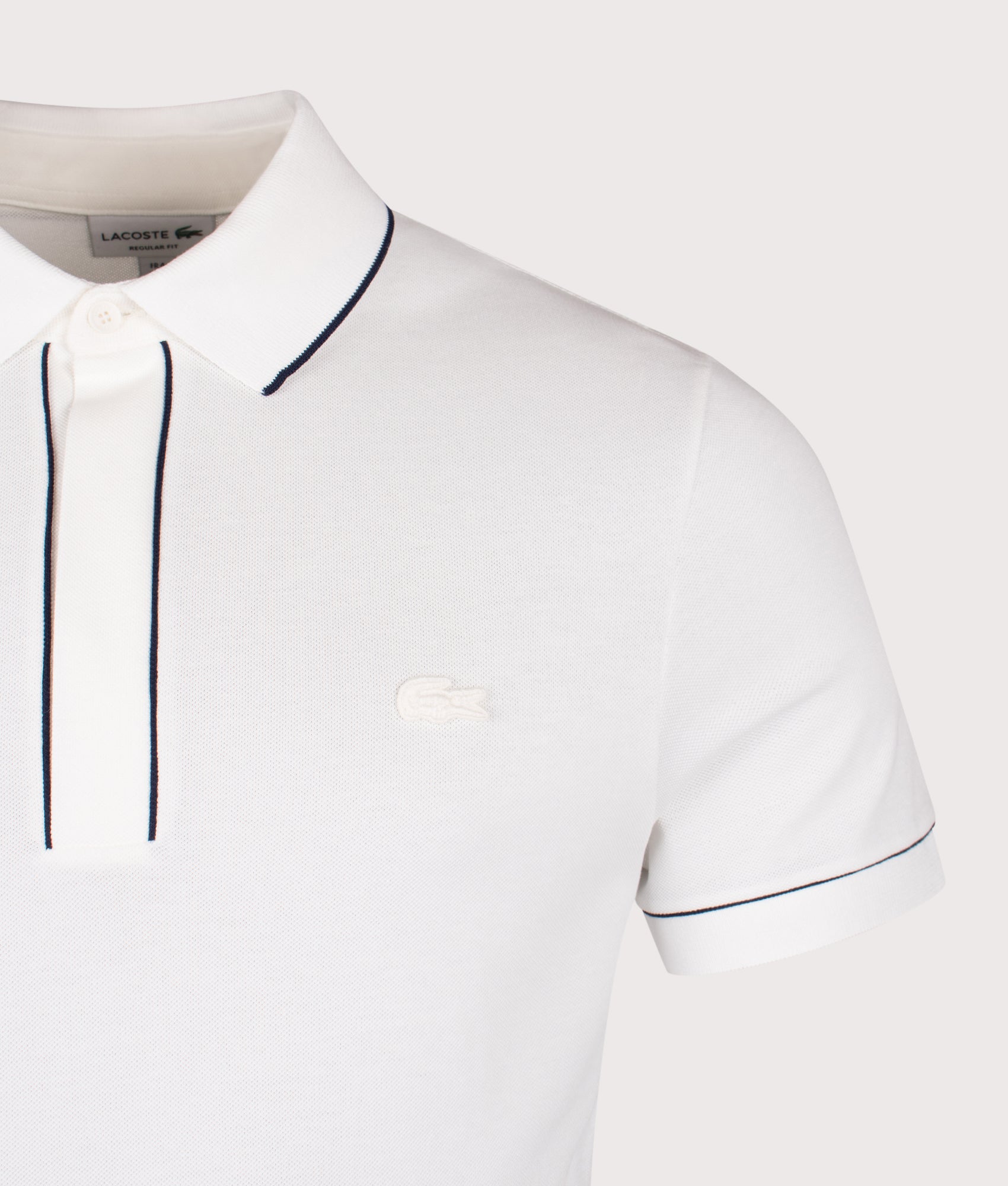 Lacoste Paris Stretch Piqué Polo Shirt in Flour at EQVVS Menswear. Detail shot.