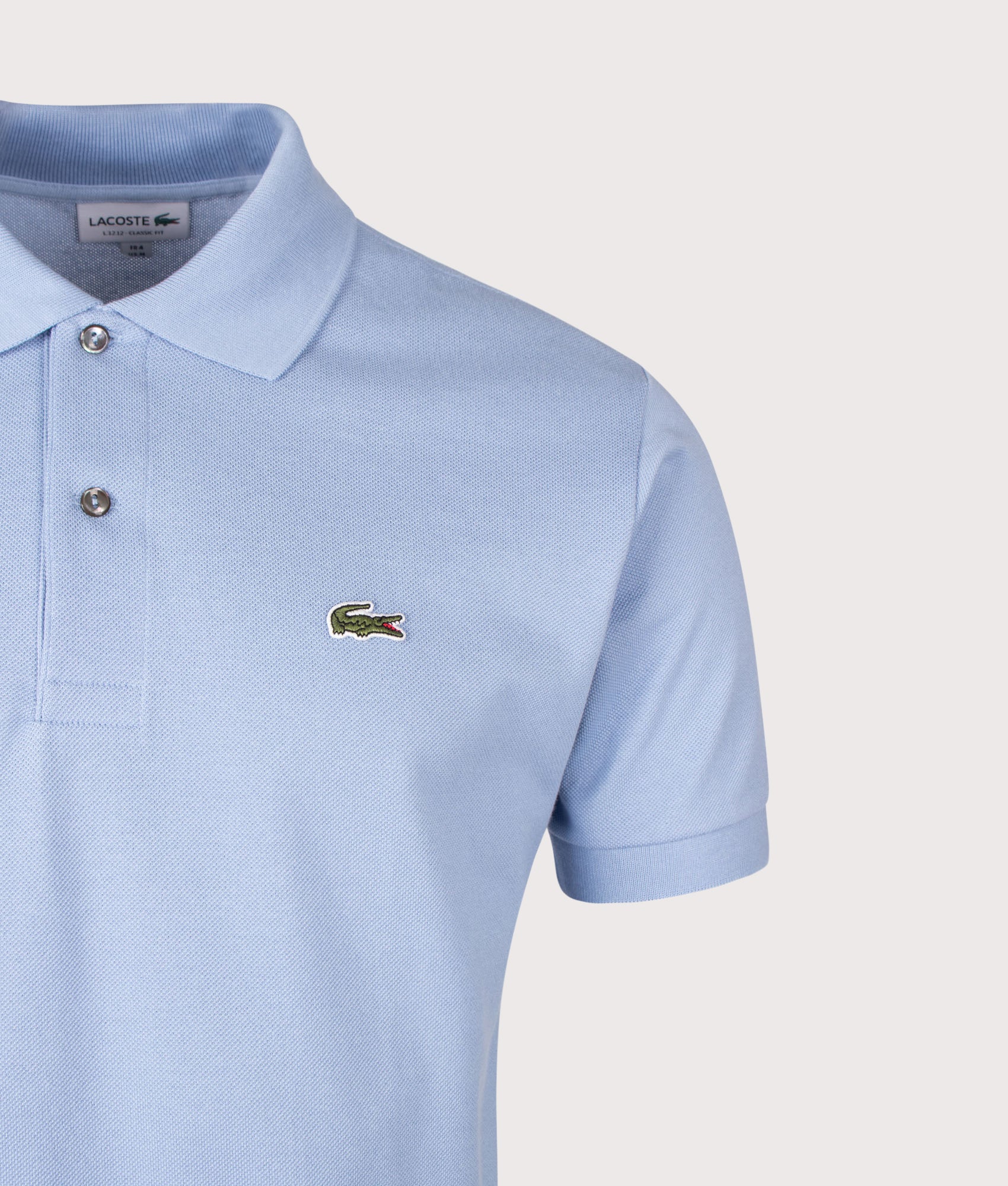 Lacoste Classic Fit L1212 Croc Logo Polo Shirt in Light Blue at EQVVS Menswear. Detail shot.