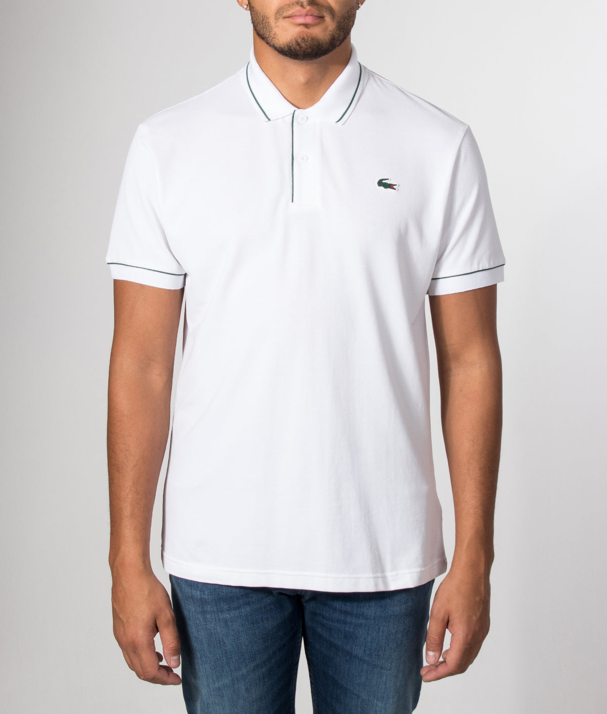 Lacoste Classic Fit Heat Regulating Mini Piqué Golf Polo Shirt in White at EQVVS Menswear. Model front shot.
