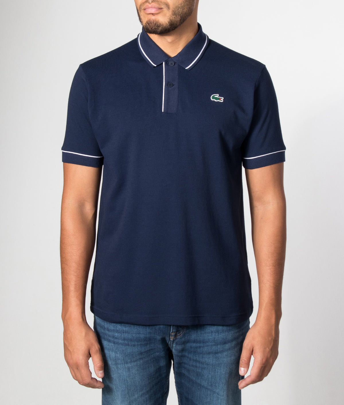 Lacoste Classic Fit Heat Regulating Mini Piqué Golf Polo Shirt in Midnight Blue at EQVVS Menswear. Model front shot.