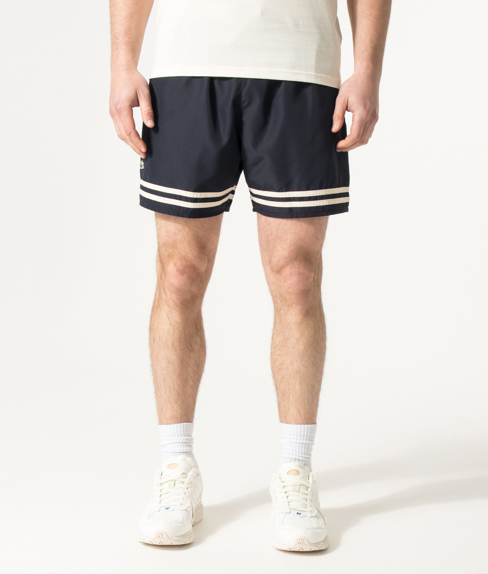 Lacoste Mid Length Contrast Stripe Swim Shorts in Blackbird and Naturel Clair at EQVVS Menswear. Model front shot.