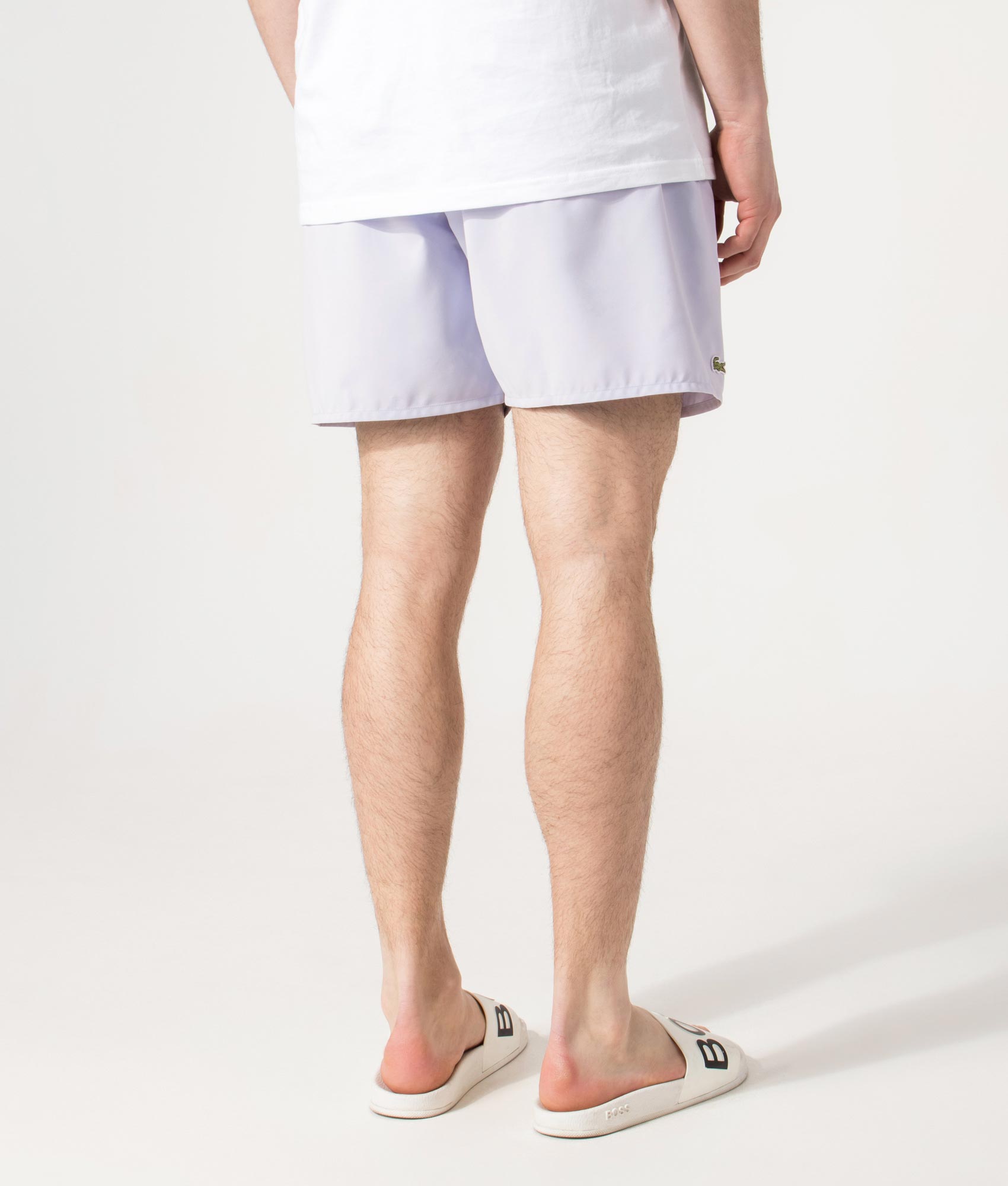 Lacoste Swim shorts in Phoenix Blue and Green at EQVVS Menswear. Model back shot.
