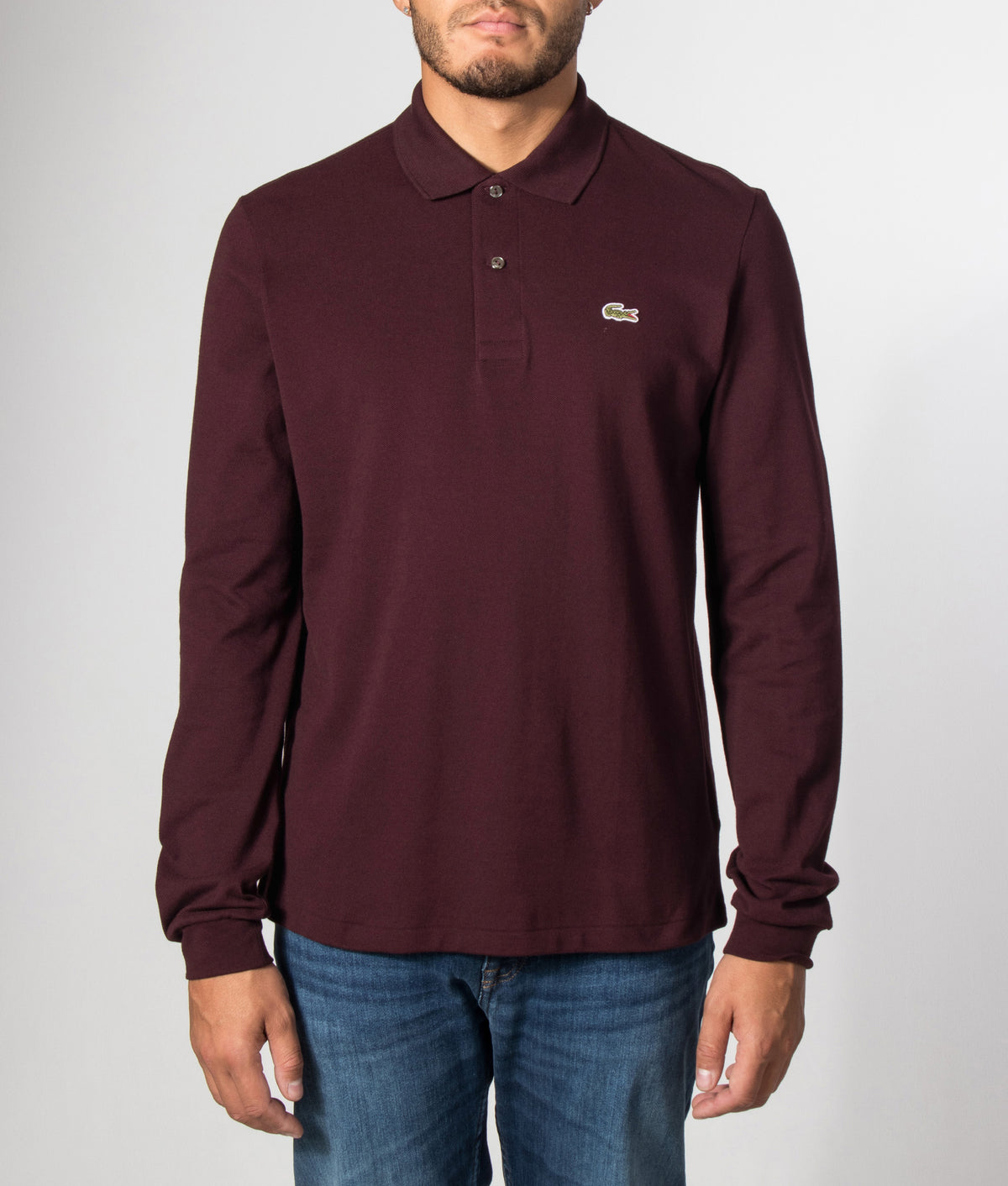 Lacoste Classic Fit Long Sleeve Croc Logo Polo Shirt in Chestnut Brown at EQVVS Menswear. Model front shot.