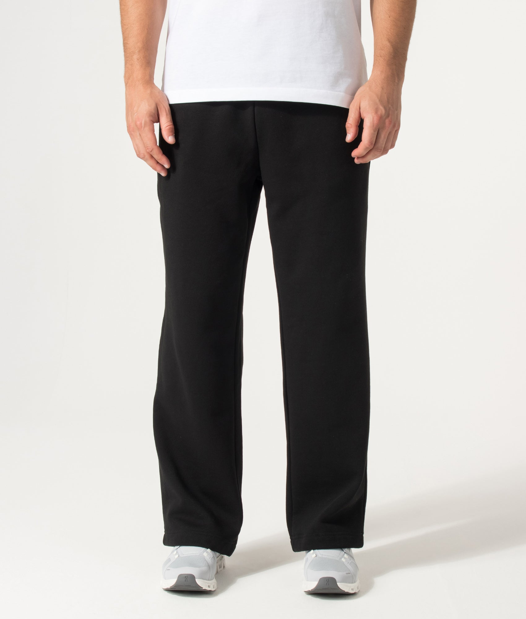 Lacoste Relaxed Fit Tracksuit Pants in Black at EQVVS Menswear. Model front shot.