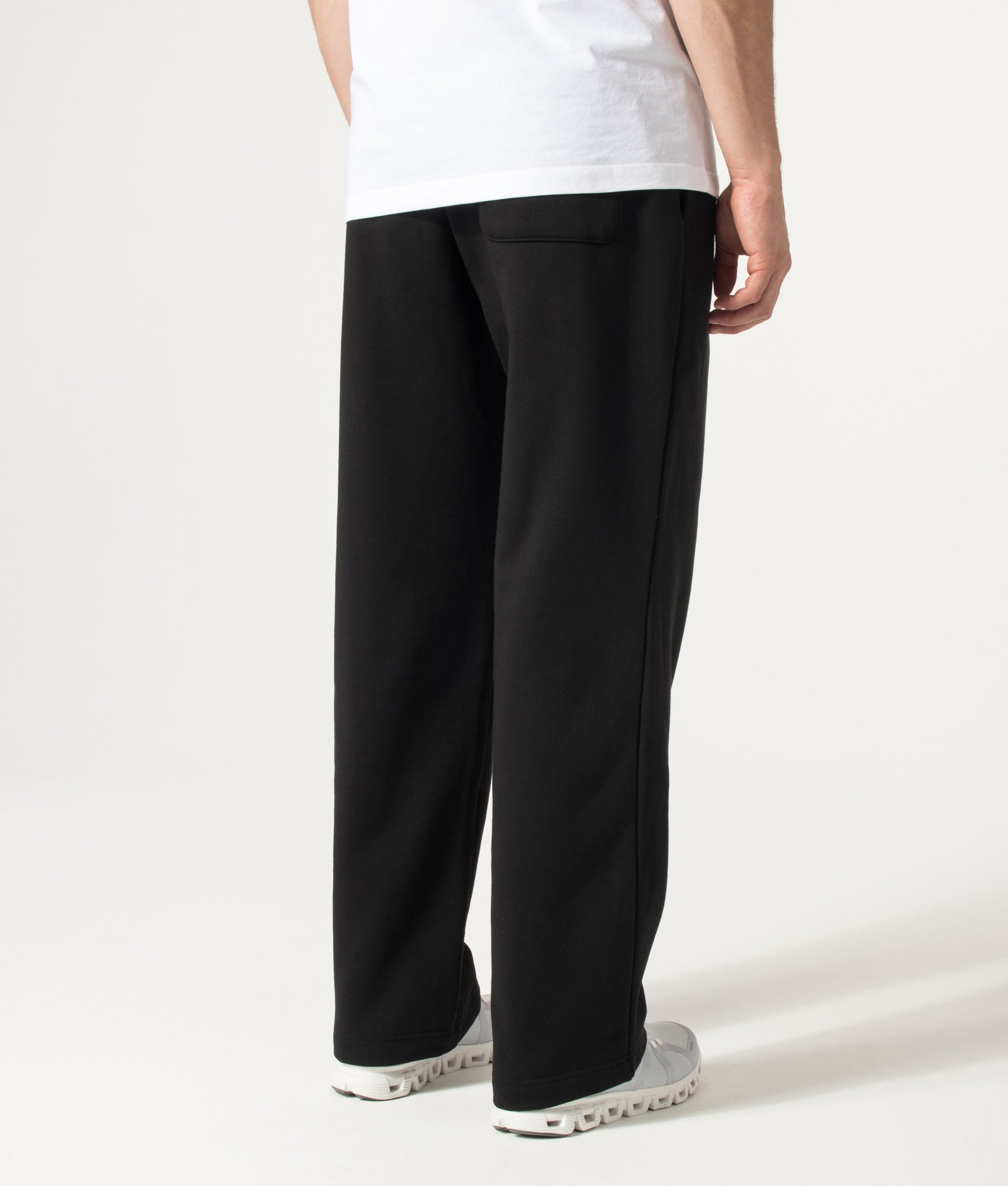 Lacoste Relaxed Fit Tracksuit Pants in Black at EQVVS Menswear. Angled model back shot.