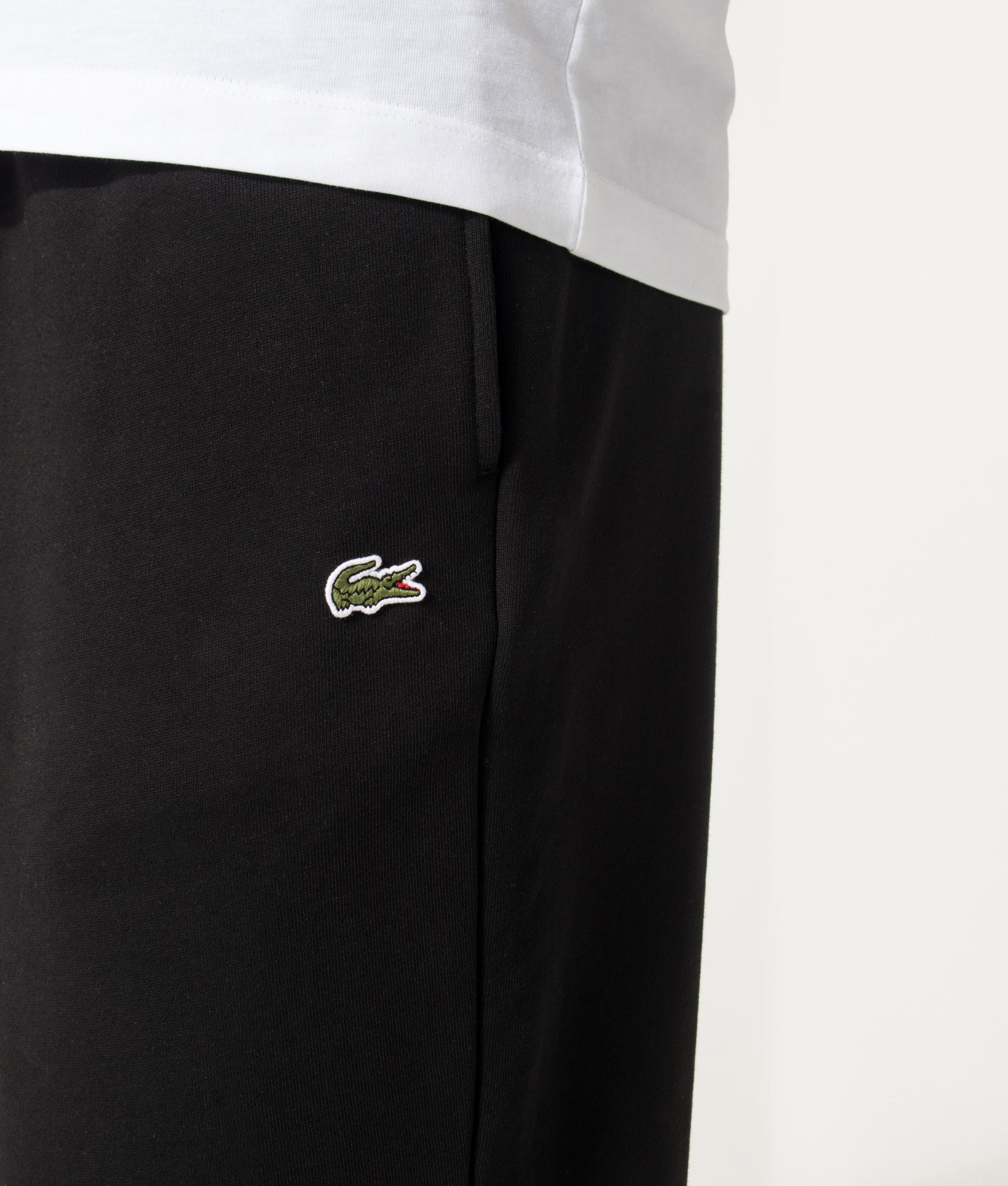 Lacoste Relaxed Fit Tracksuit Pants in Black at EQVVS Menswear. Detail shot.
