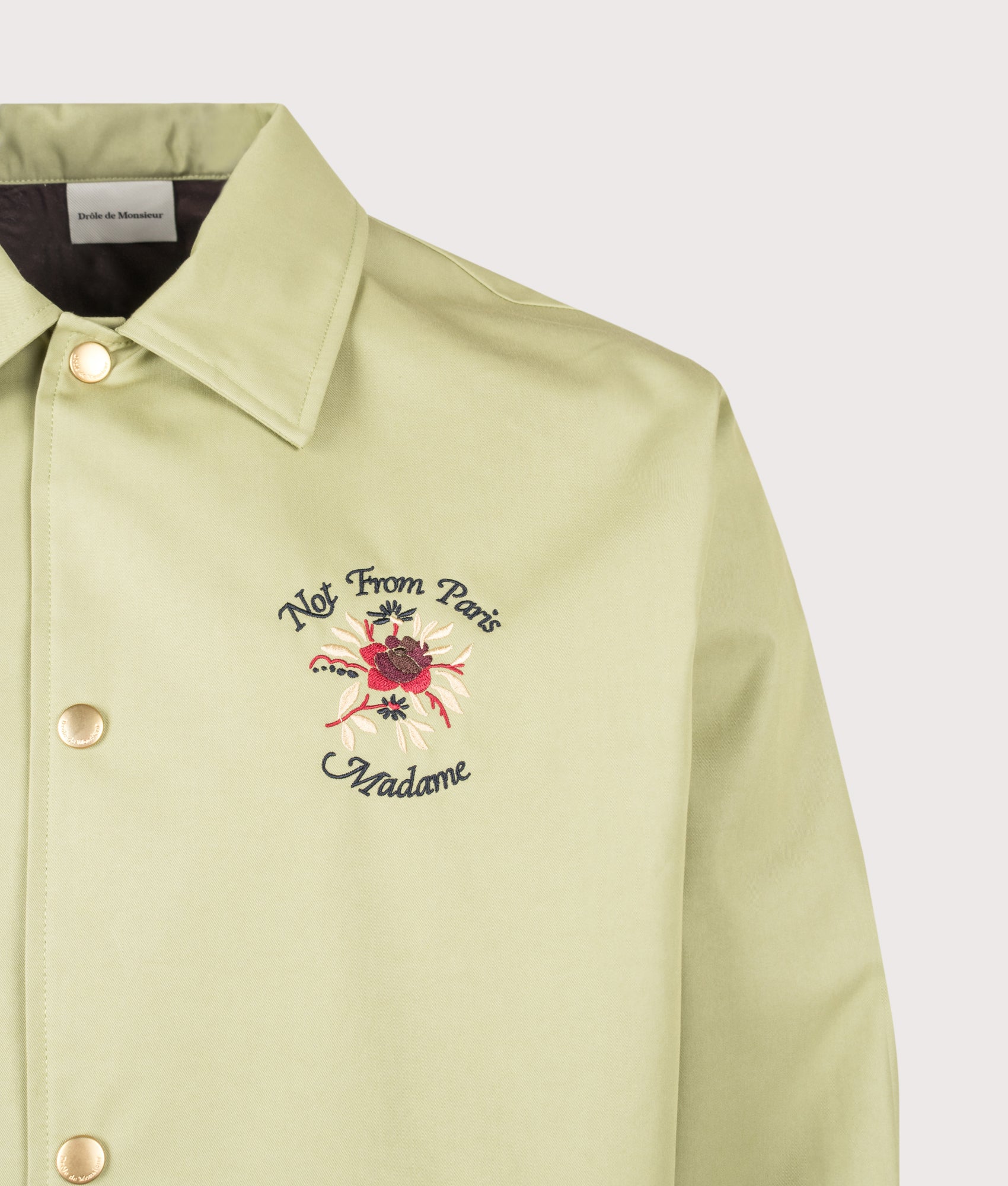 Slogan Rose Lightweight Jacket in Olive by Drôle de Monsieur. Shot by EQVVS. Detail shot.