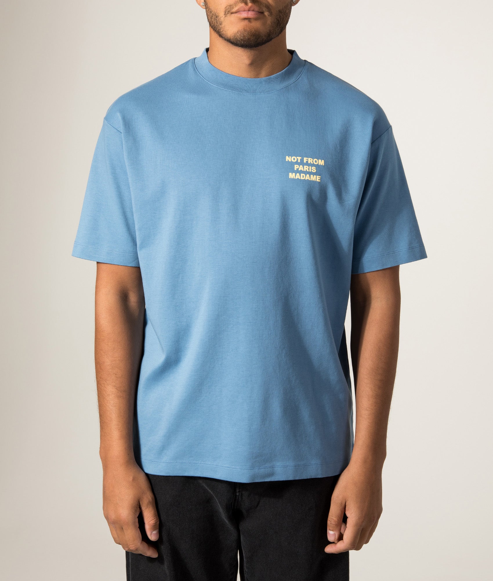 Drôle de Monsieur Relaxed Fit Slogan T-Shirt in Atlantic Blue at EQVVS Menswear. Model front shot.