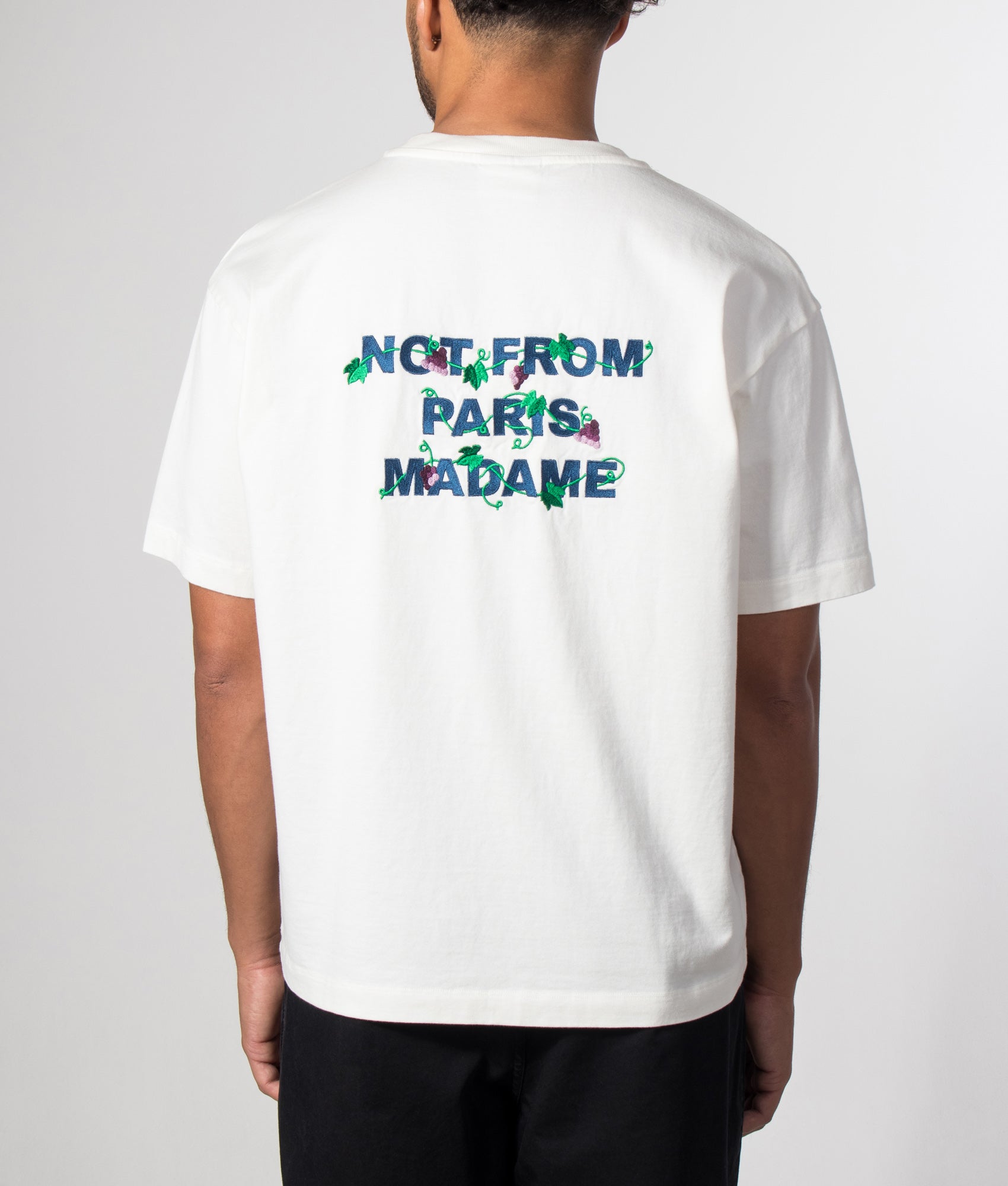 Drôle de Monsieur Relaxed Fit Vine Embroidered Slogan T-shirt in Off White at EQVVS Menswear. Model back shot.