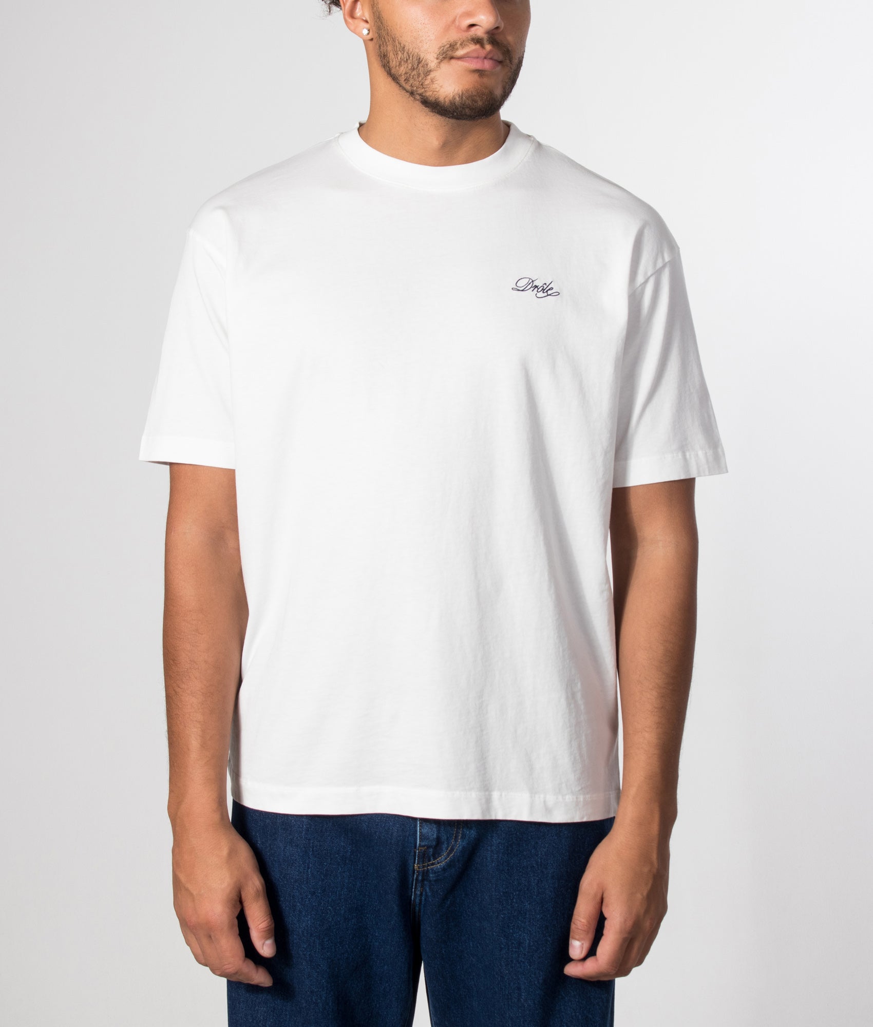 Drôle de Monsieur Relaxed Fit Drôle Belissima T-shirt in Off White at EQVVS Menswear. Model front shot.