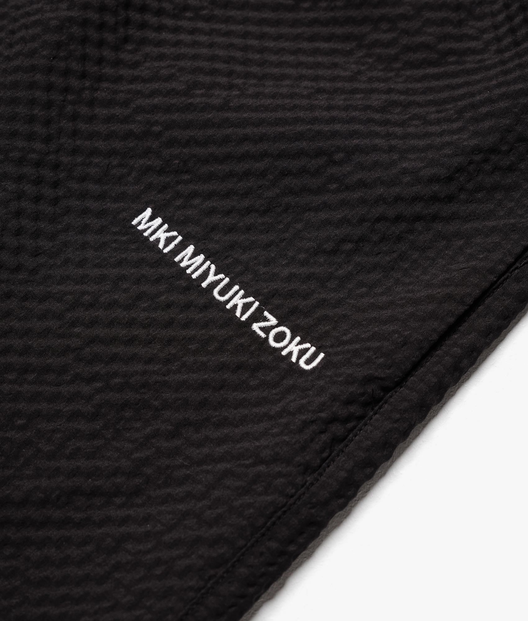 Relaxed Fit Seersucker Trousers in Black by MKI MIYUKI ZUKO, EQVVS Detail Shot.