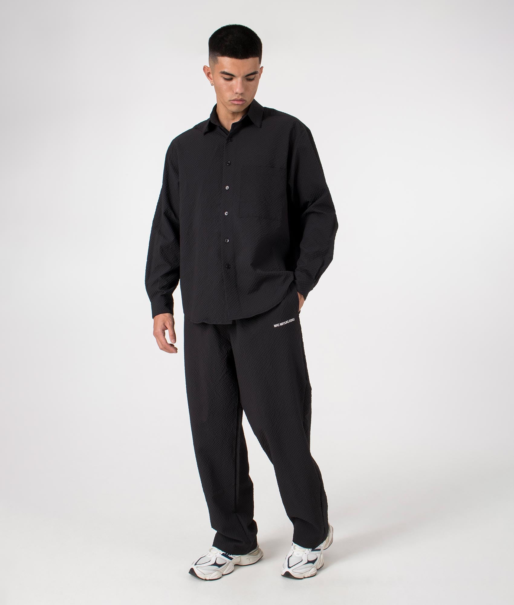 MKI Relaxed Fit Seersucker Trousers in Black. Full front angle model shot at EQVVS.