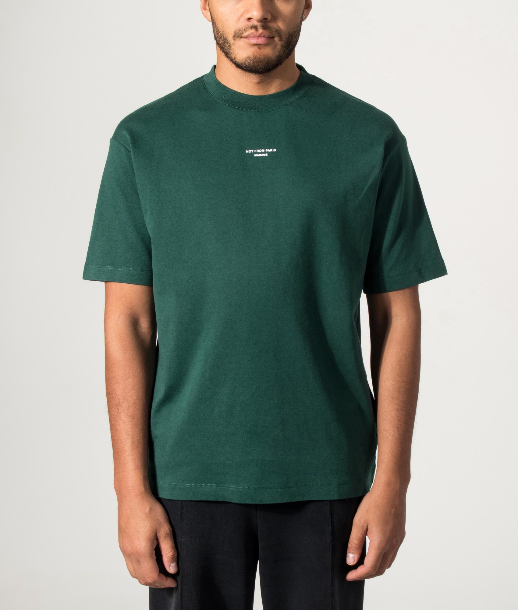 Drôle de Monsieur Relaxed Fit Classic Slogan T-shirt in Dark Green at EQVVS Menswear. Model front shot.