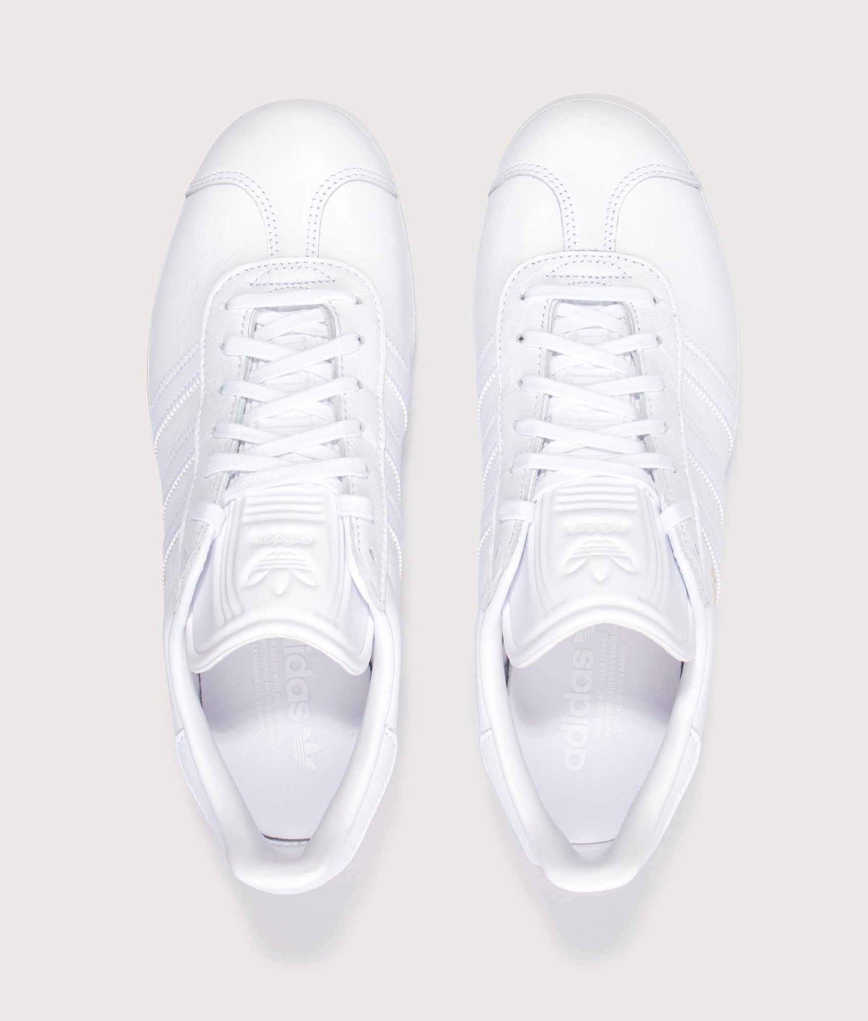 adidas Originals Gazelle Trainers in White/White/Gold Metallic at EQVVS Menswear. Top shot.
