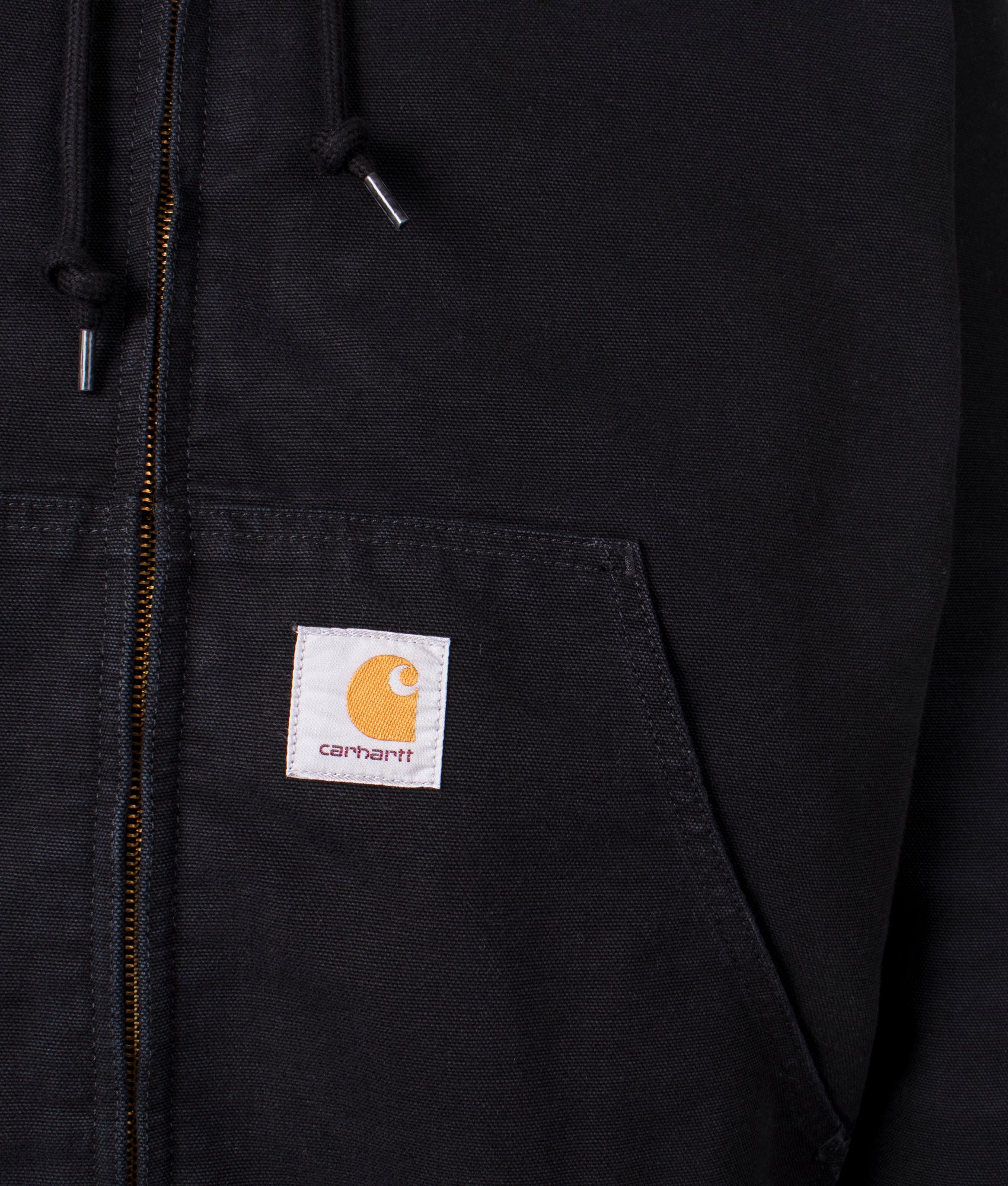 Carhartt OG Active Jacket in black, 100% cotton at EQVVS menswear. Logo detail shot. 