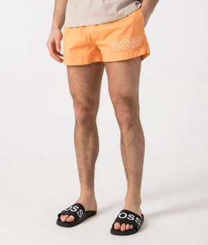 BOSS Mooneye Swim Shorts in Medium Orange. Side angle shot at EQVVS.