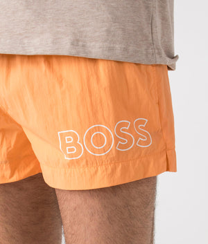 BOSS Mooneye Swim Shorts in Medium Orange. Detail shot at EQVVS.