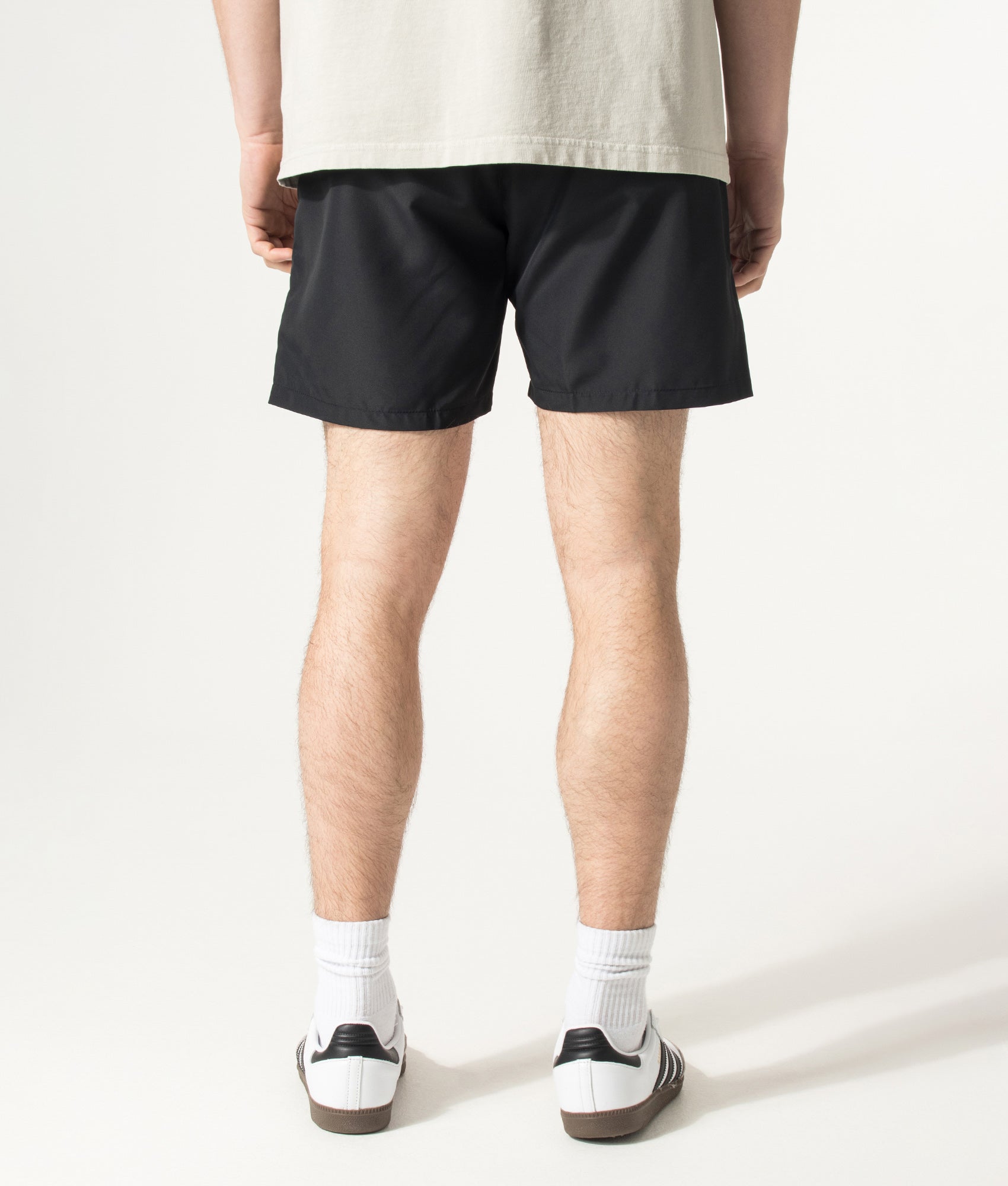 BOSS Starfish Swim Shorts in Black at EQVVS Menswear. Model back shot.