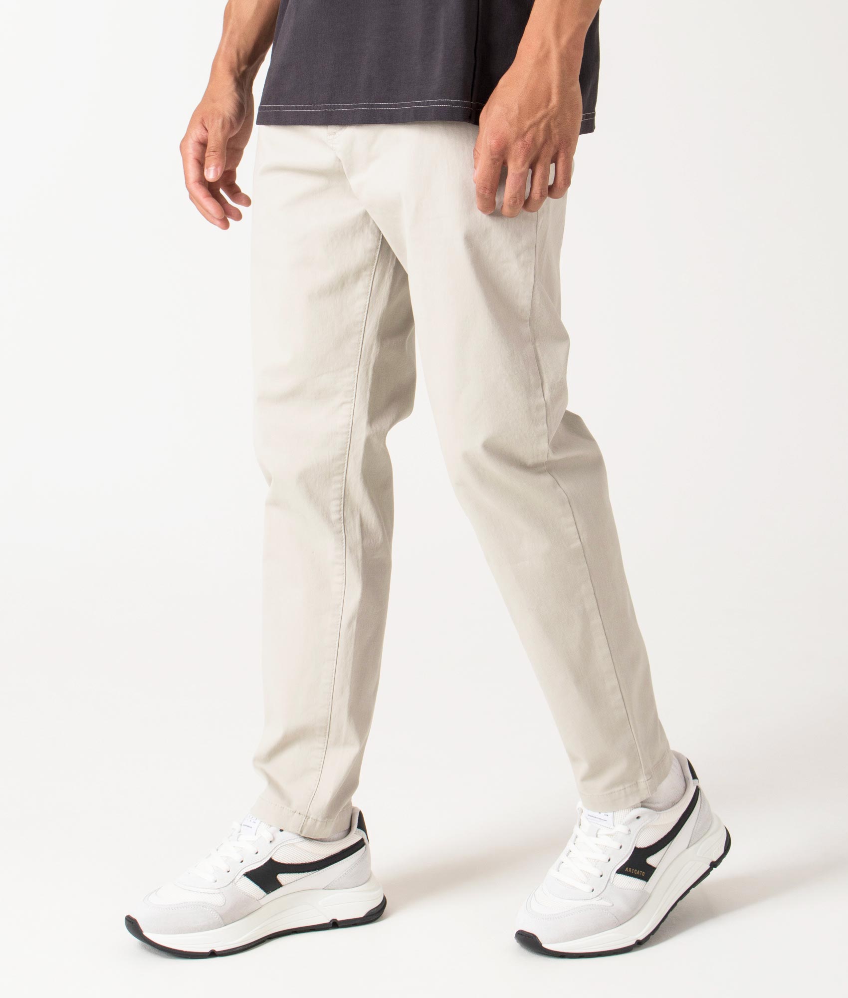 Chino Tapered Pants in light beige by BOSS. Shot at EQVVS. Side shot. 