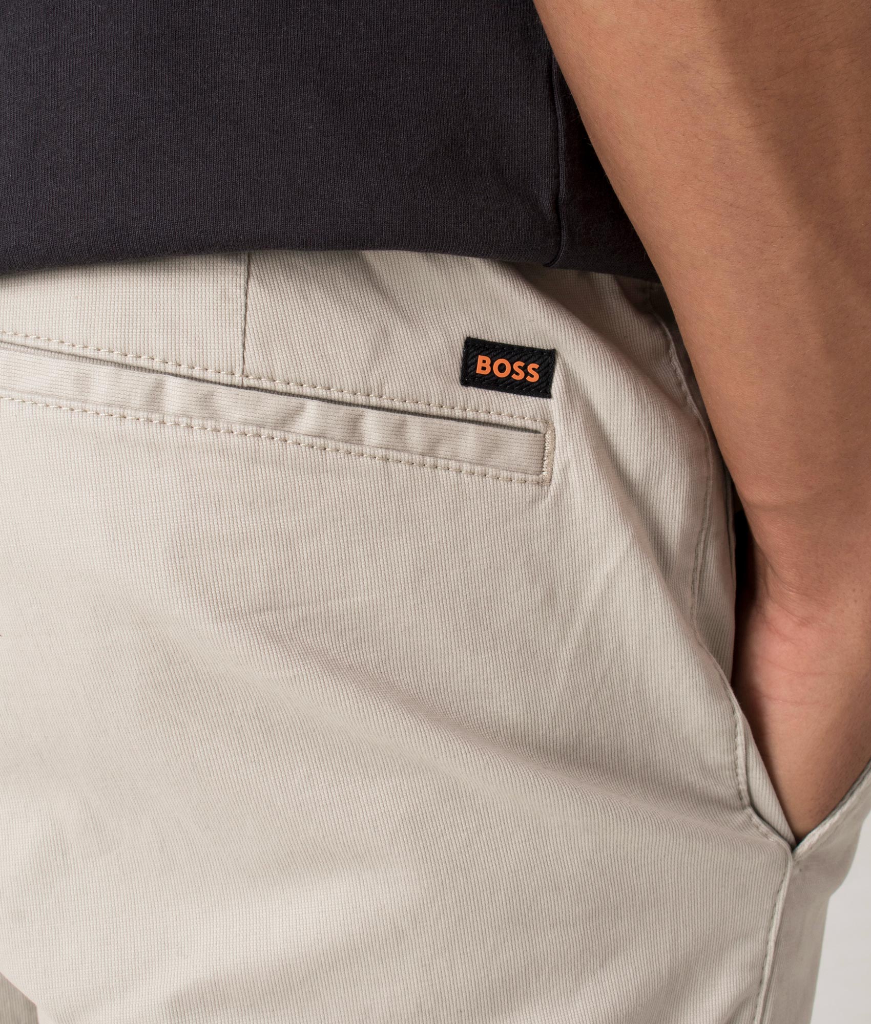 Chino Tapered Pants in light beige by BOSS. Shot at EQVVS. Detail shot. 