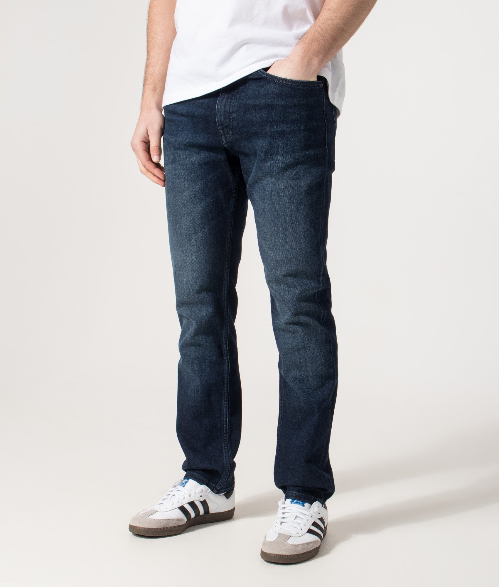 BOSS Slim Fit Delaware Jeans in the Dark Blue at EQVVS Menswear. Angled model front shot.